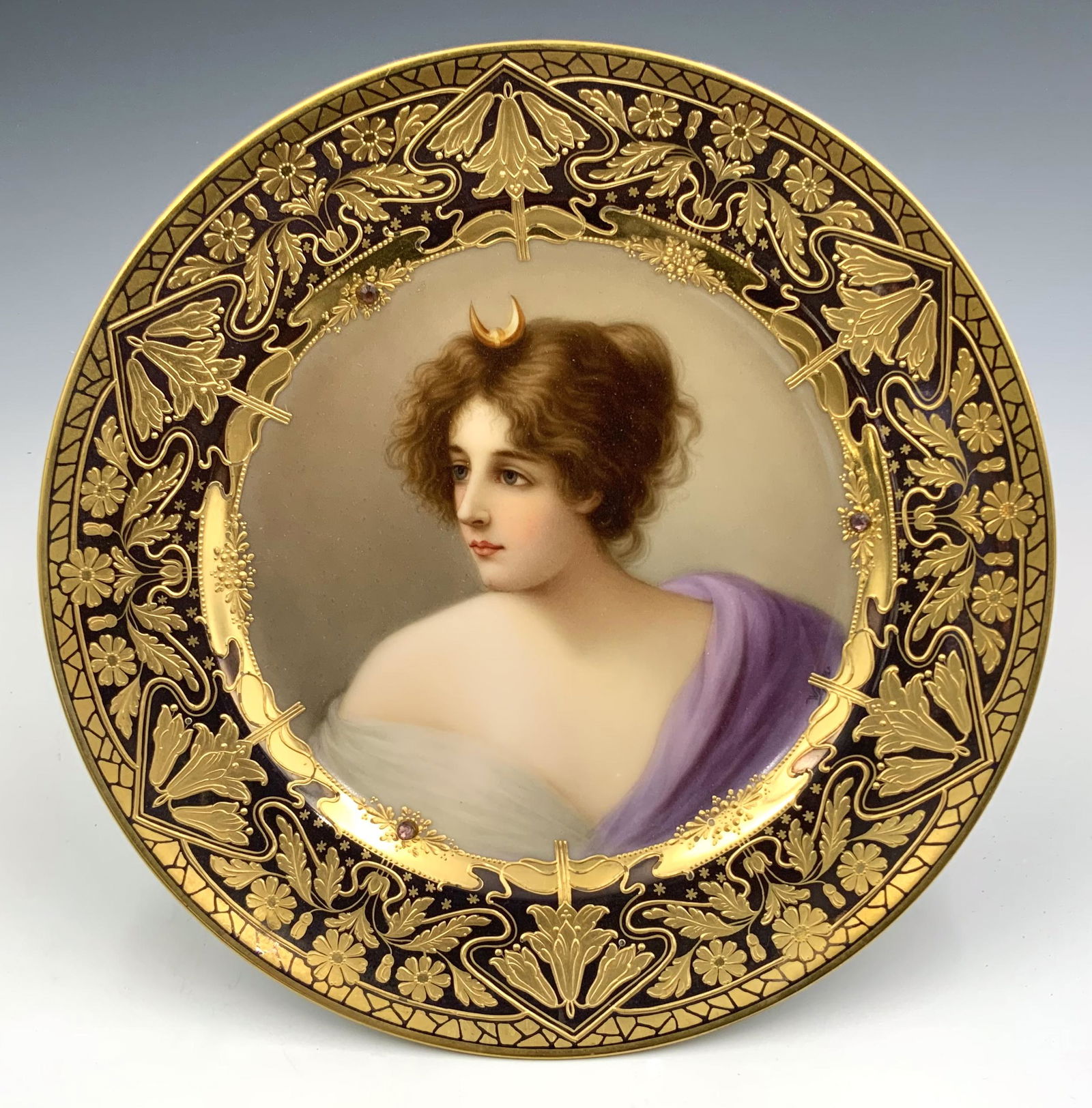 Royal Vienna Gilded Portrait Plate- "Diana".: Signed "Wagner" on the front, with the title and Royal Vienna beehive mark on the back. The image is of a young brunette with a purple and white wrap. The border is painted with intricate gold enamel
