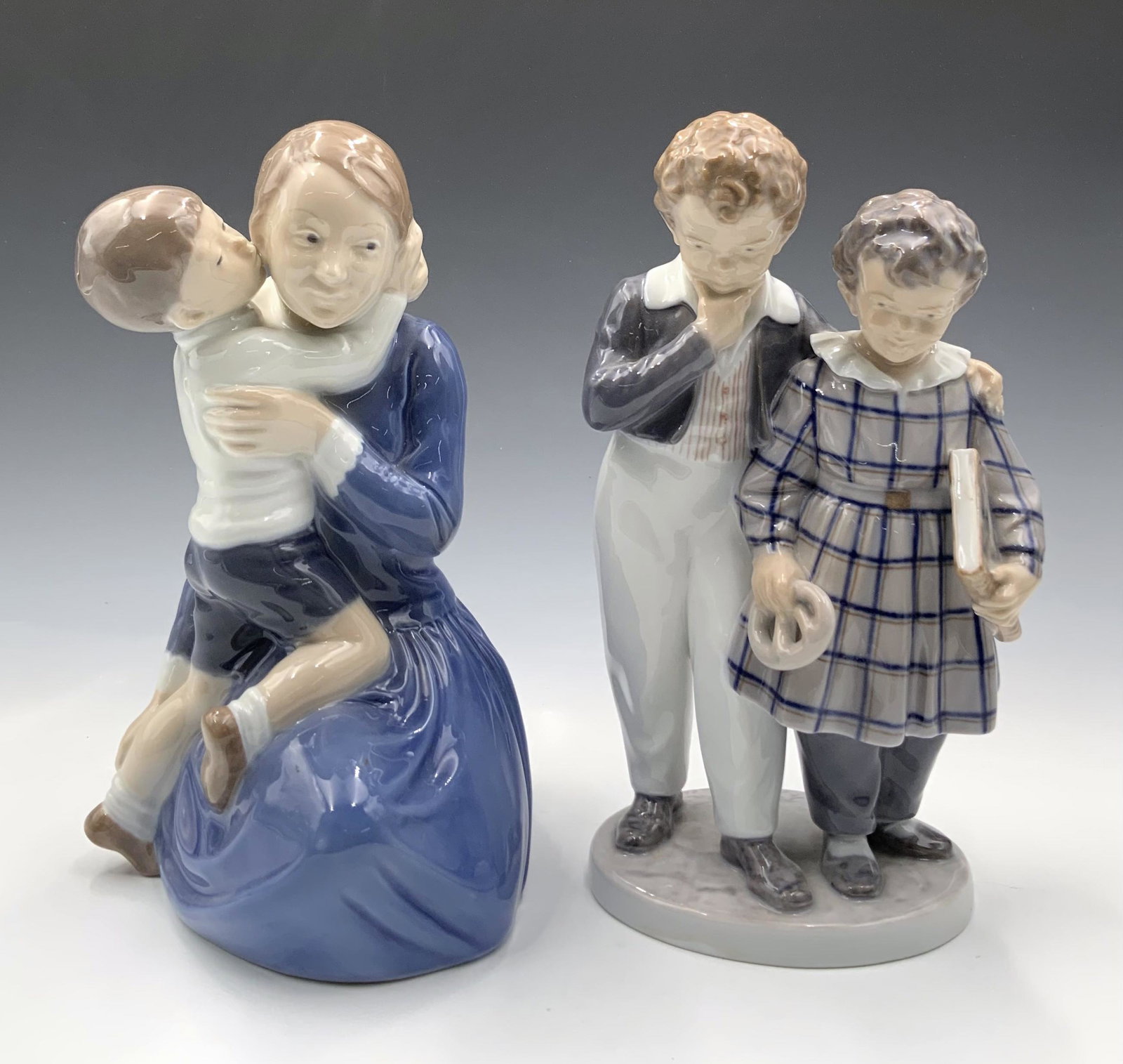 Lot of 2 Royal Copenhagen Child Figurines.: These are Numbered 3457 and 1761. The boy and girl figure is Signed by artist Christian Thompson. The mother and child figure has a tiny Nick on the back, near the bottom. Both figurines measure about