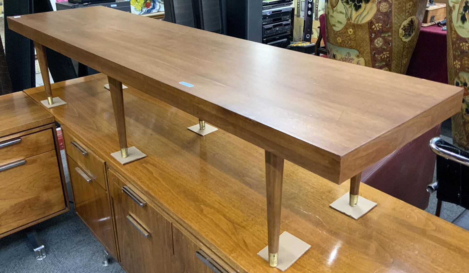 Mid-Century Long and Low Coffee Table, unbranded.: This mid-century modern table is in a medium walnut finish, with nice graining to the wood. It is in Good condition, except for a small cigarette burn at one end, and a small chip near the corner. It