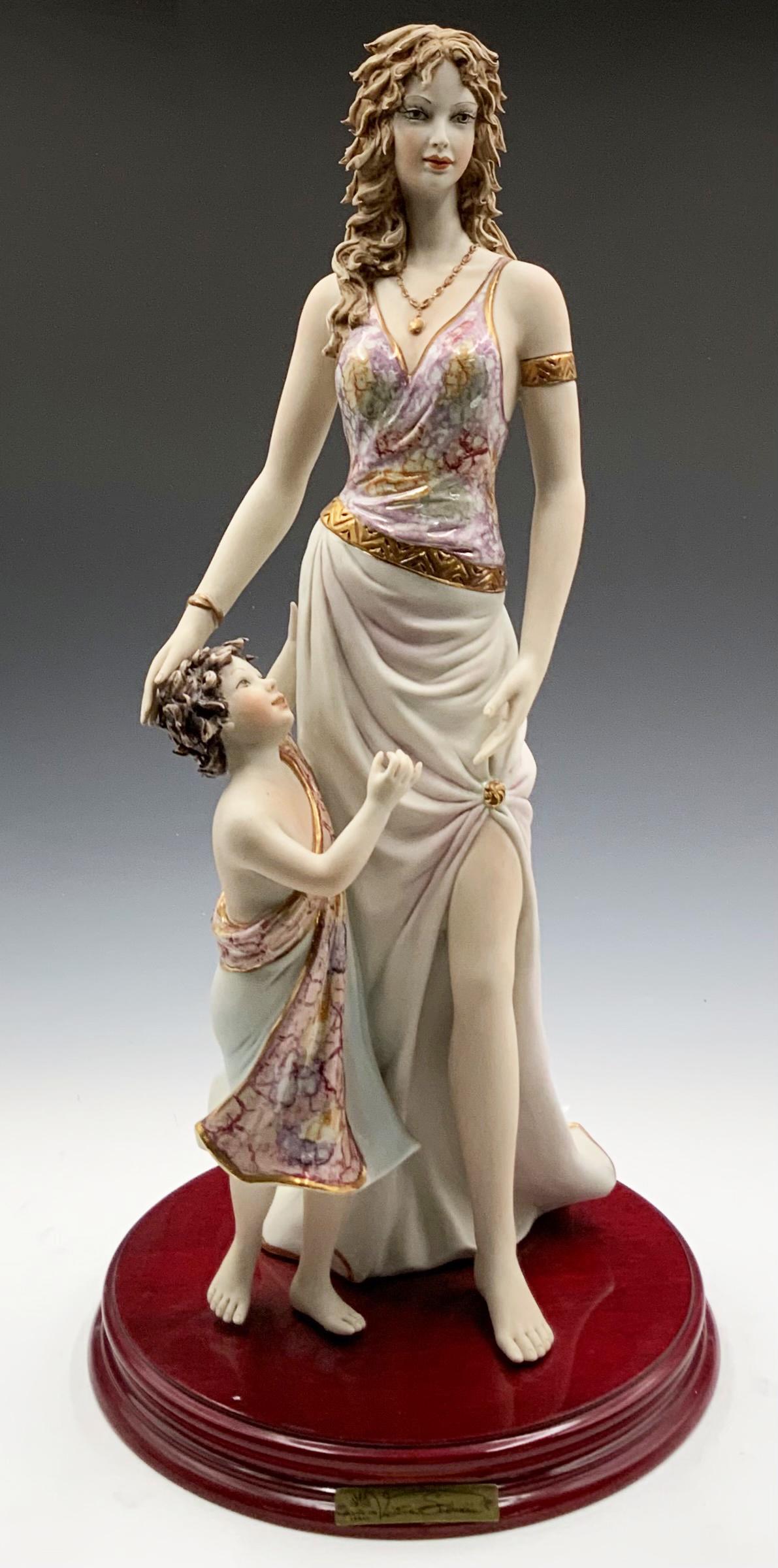 Vittorio Sabadin Figurine of Woman w/ Child.: The Figure is of a mother with her young son, both of them dressed in multicolor tunics. It is Signed, and also has an identifying plate on the front of the base. It Looks to be in Nice cosmetic condi