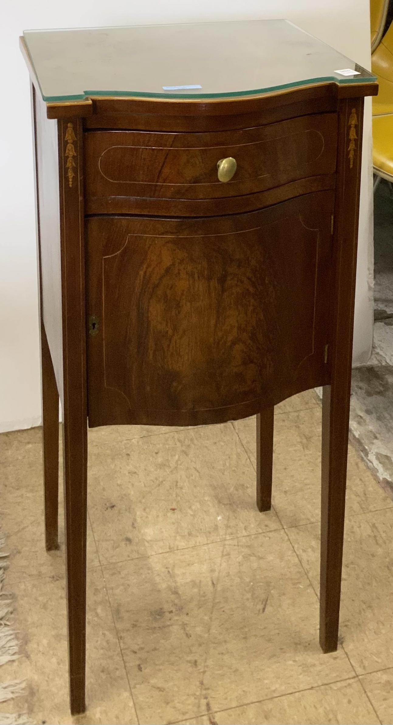 Sheraton-Style Inlaid Mahogany Nightstand.: This mahogany nightstand has a single drawer and a door with an interior cabinet. It has a custom glass top. The front of the nightstand is curved in shape. There is some discoloration to its top, but