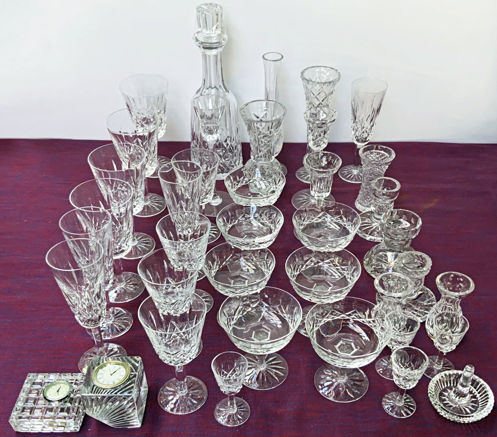 39 Pc. Lot of Waterford Crystal- Goblets, etc.: The lot Includes a decanter, sherbert glasses, wine goblets, flutes, vases, candlesticks, cordials, a ring dish, and clock paperweights. The Lot looks to be in Very Nice condition overall. A few piece