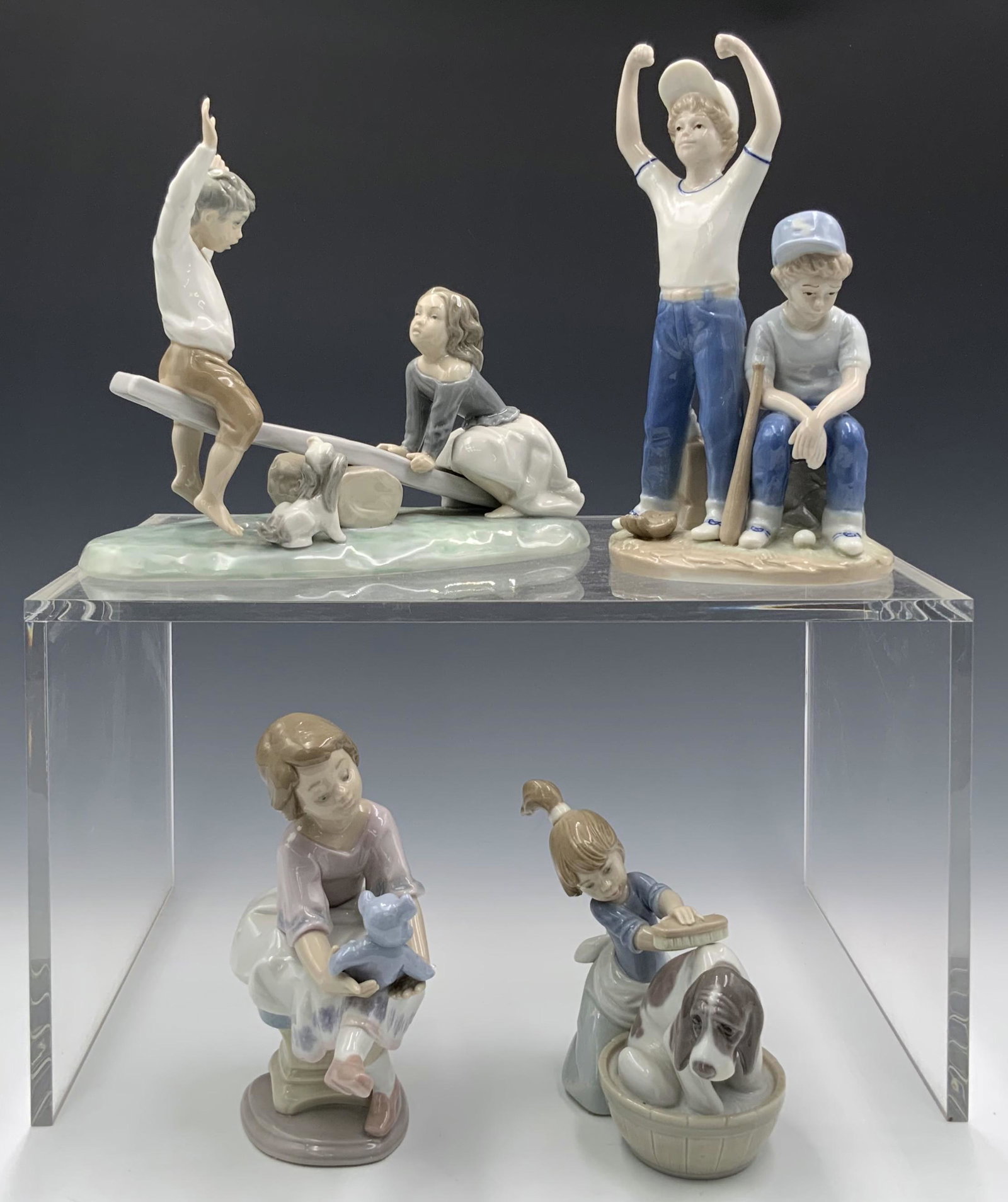 Lot of Children Figurines, Mostly Lladro.: They look to be in Very Nice condition. Three of them are Lladro, one is marked as Paul Sebastian. The Lladros are a boy and girl on a seesaw, a girl with a Teddy bear, and a girl washing her dog. The