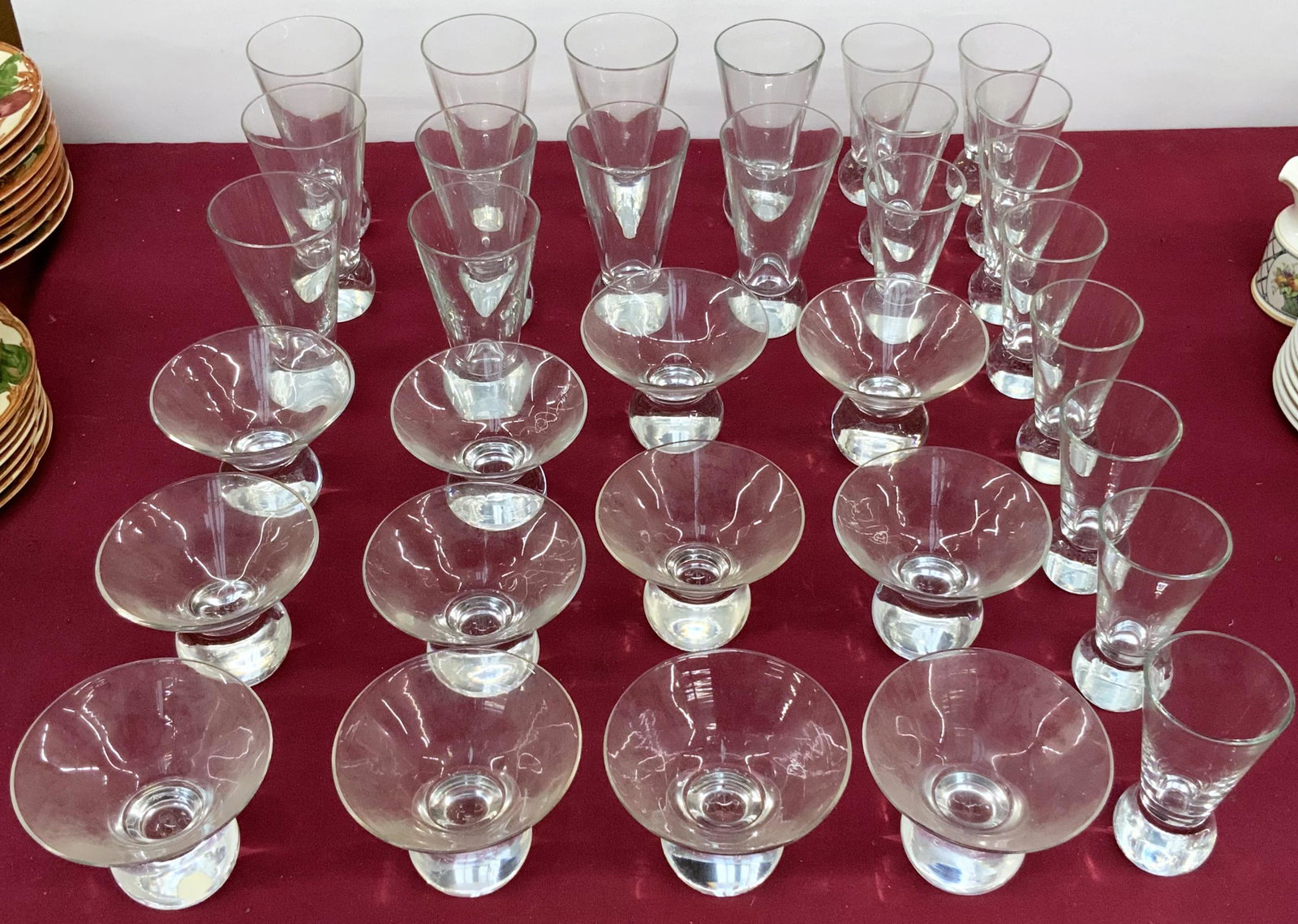 33 pc. Lot of Mid-Century Modern Glassware.: There are eleven flutes, ten larger glasses, and twenty-two coupe glasses. The lot is not marked. They appear to be in very good cosmetic condition. There are minor scratches to the bottoms from use. 