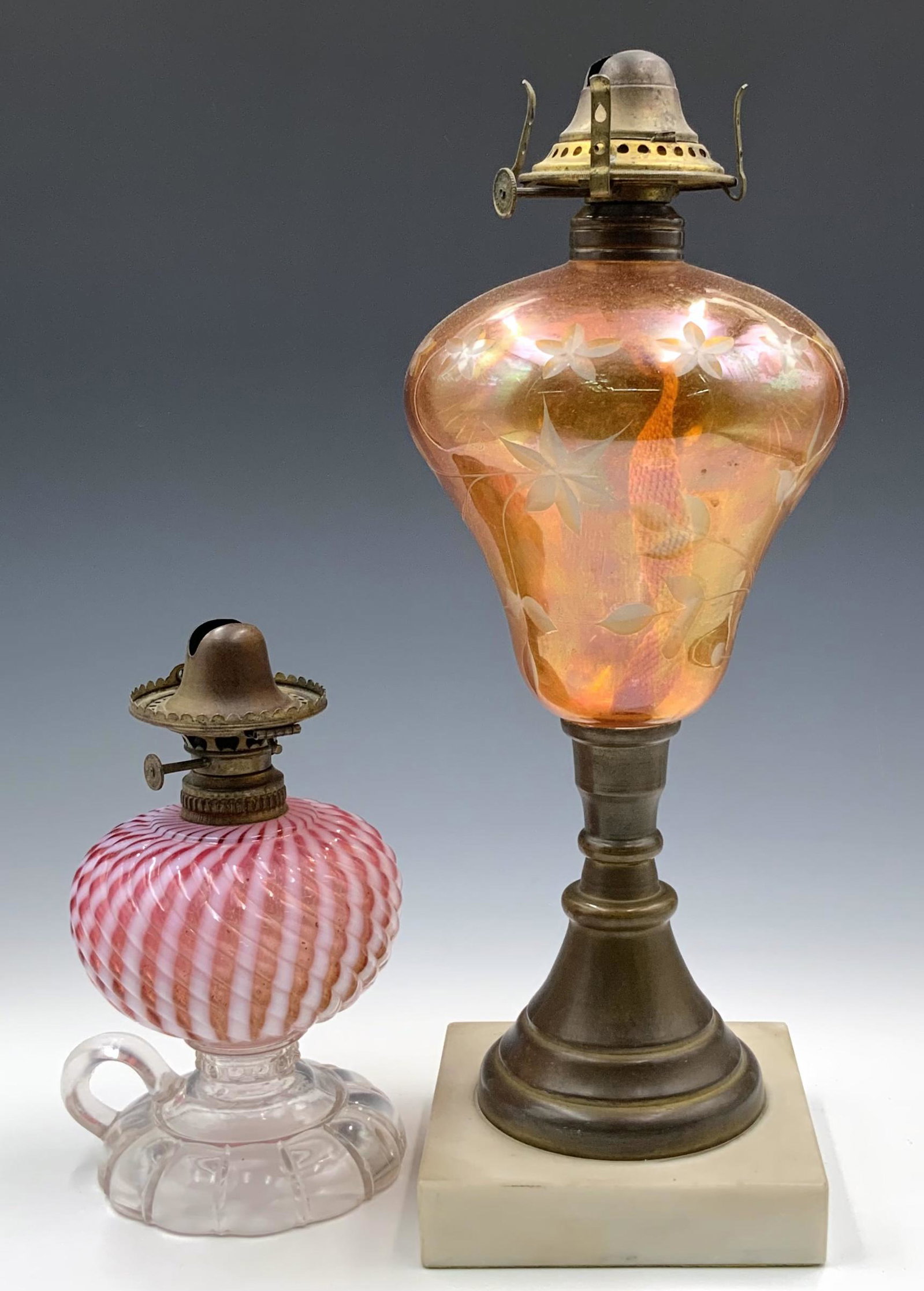 Lot of 2 Antique Glass Oil Lamps.: The smaller one is a Sheldon swirl lamp in cranberry and white. It has a few Chips near the bottom. The larger lamp is amber glass, with an etched eagle design. It measures 14 1/4" tall. In-house Ship