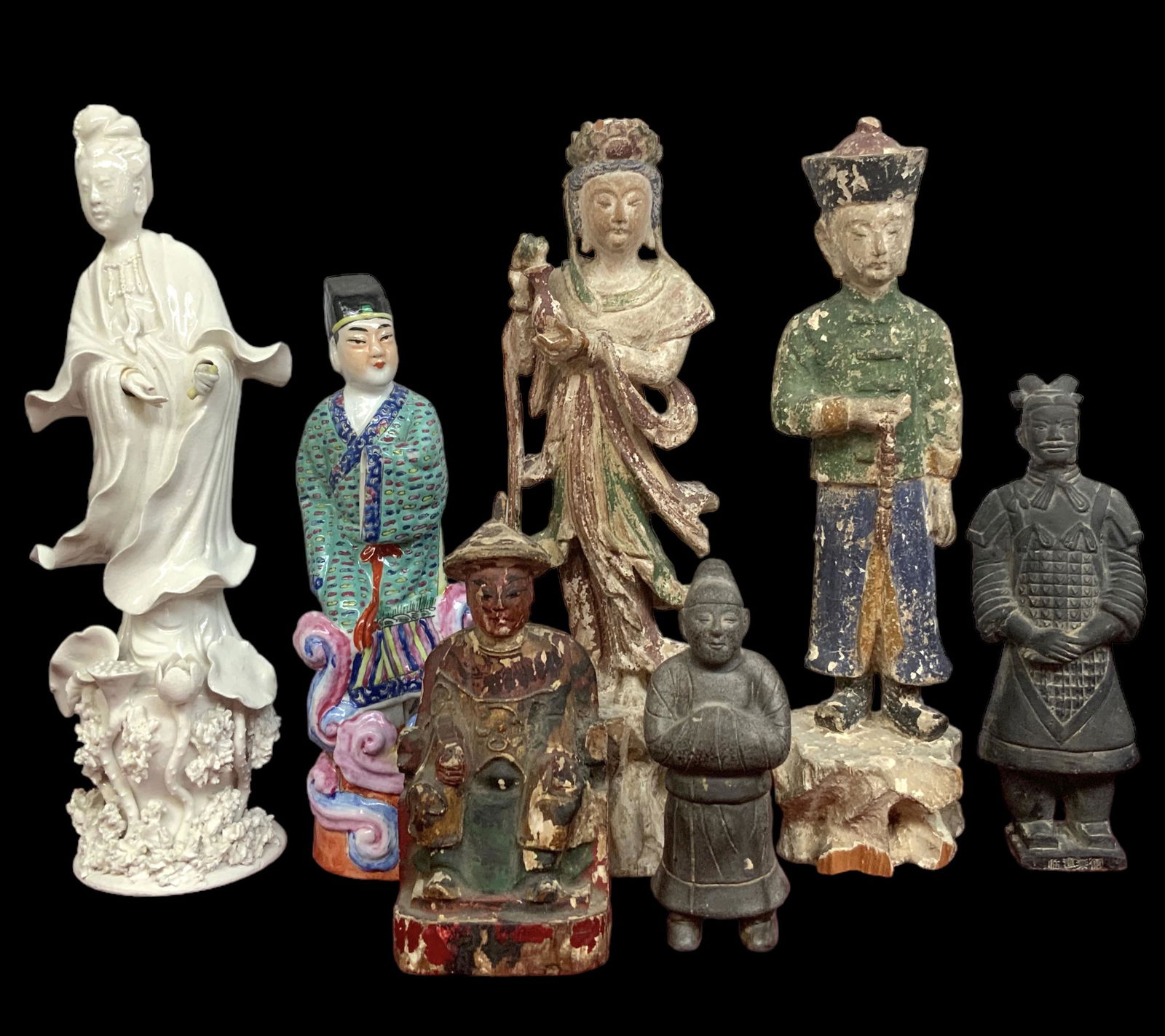 Lot of 7 Chinese Figurines, inc. Carved Wood.: Most of these are older Figures. The Blanc de Chein Guan Yin Figure has a Broken Thumb, and is missing the flower in her hand. The Colorful Porcelain Figure of man is missing his hand. The Wooden Figu