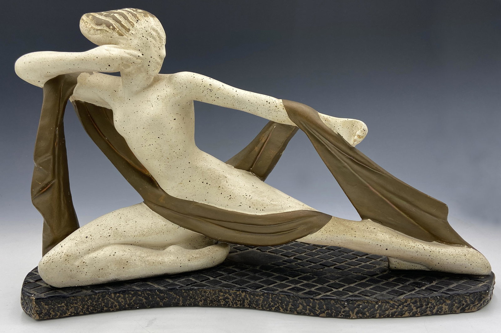 Painted Mid-Century Art Deco Composition Lamp.: This Deco style lamp is of a reclining nude woman with her arms drawn, as if she's holding a bow and arrow. The lamp is in working condition. It has some scratches and areas of missing paint. The lamp