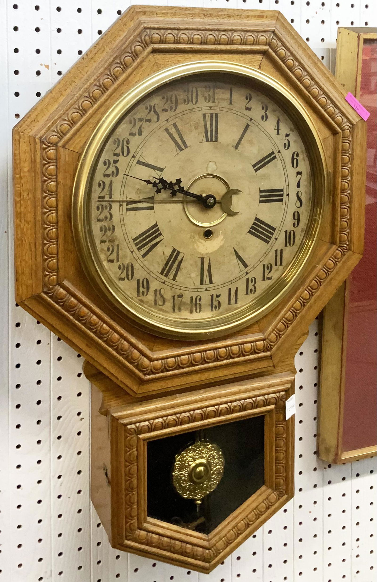 Antique Oak Calendar Clock, Maker Unknown.: The Clock Face is darkened, and has some scrape marks from the Hands going around. It comes with a Key and the Pendulum, and it ticks. It measures 27 1/4" Long. Third-party shipping or personal pickup