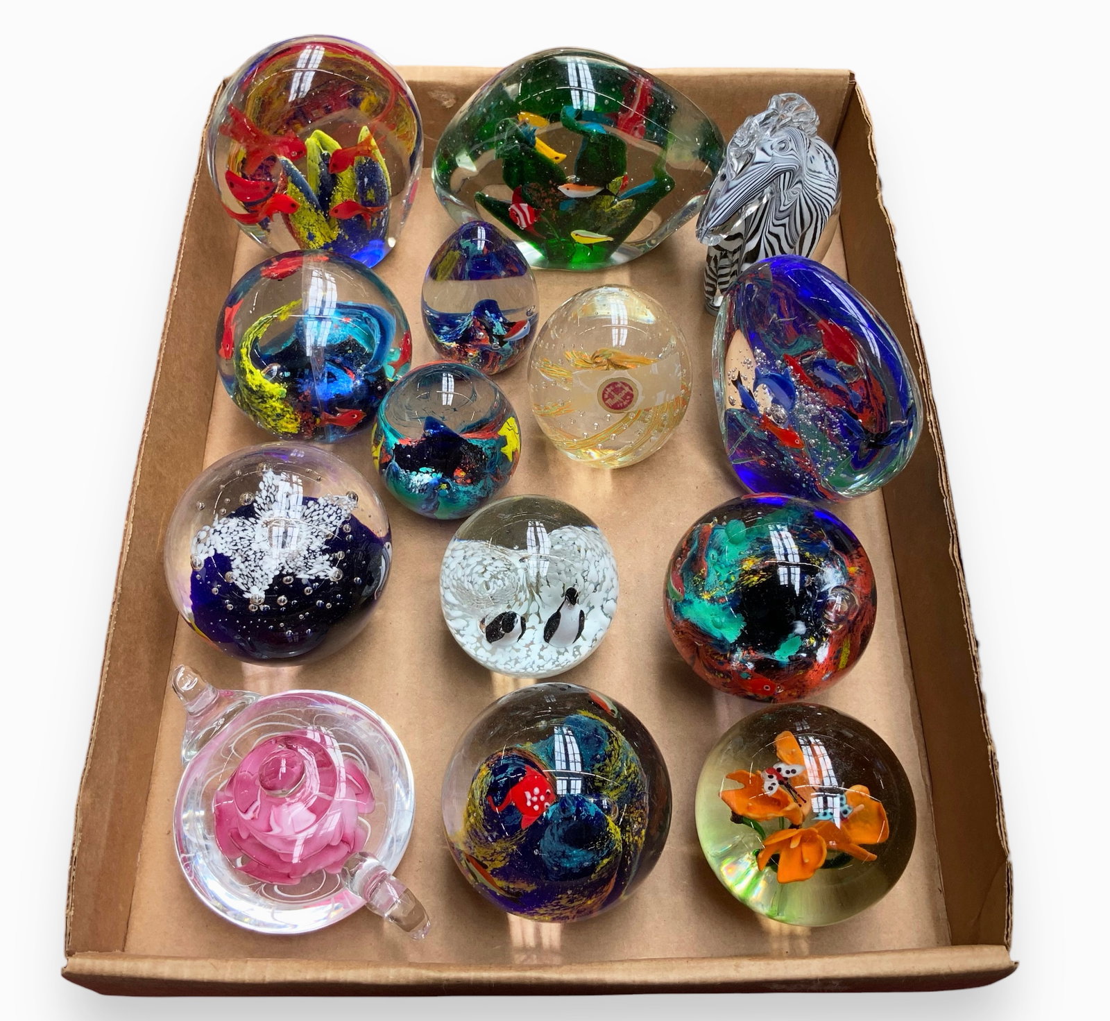 Lot of 14 Mostly Animal Themed Glass Paperweights.: Many of them have fish designs. One is shaped like a zebra, and another has a penguin motif. One of the paperweights that is not animal-themed has a Murano sticker. The others appear to be Unsigned. T