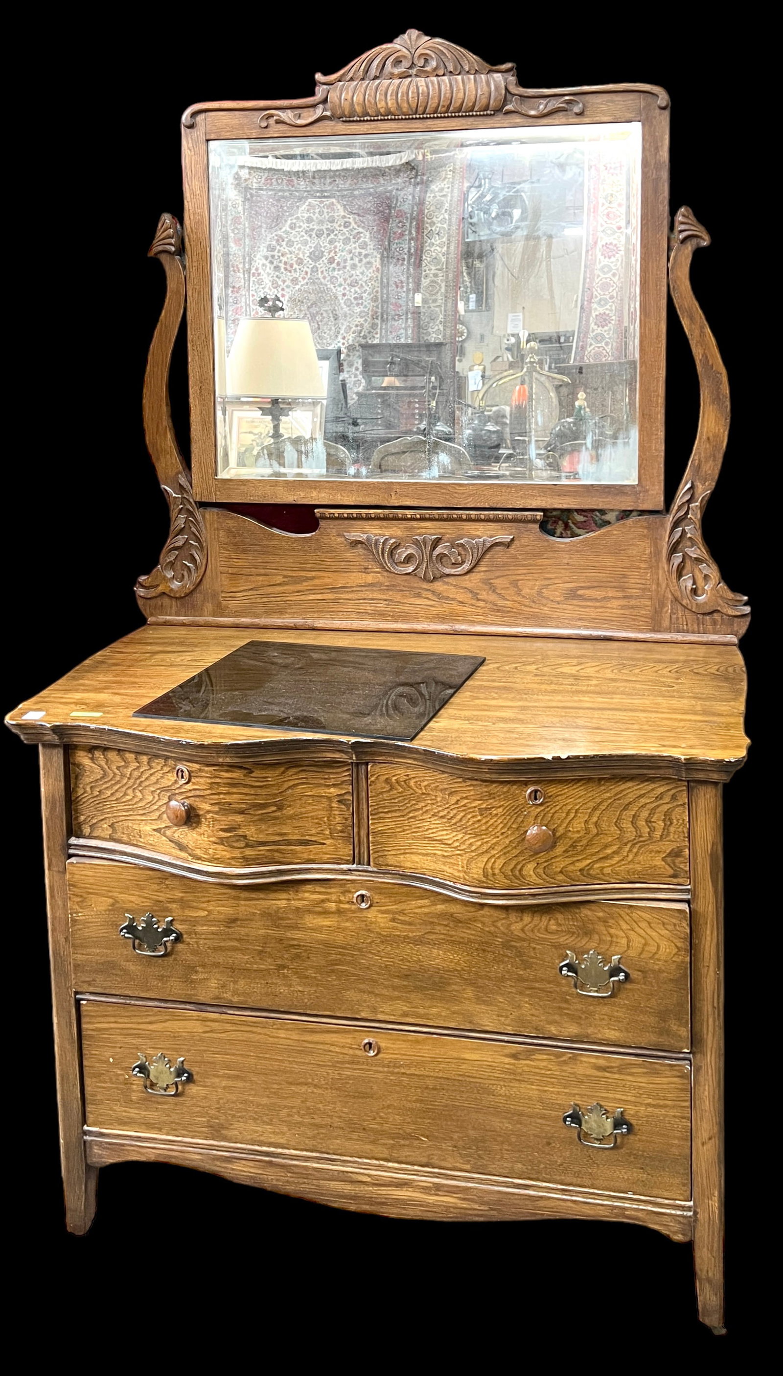 Antique Oak Dresser with Mirror.: This is an antique carved oak four drawer dresser with a swing mirror. It has a bowfront design. All the hardware seems to be original. The mirror has some de-silvering, and there are small gouges on 