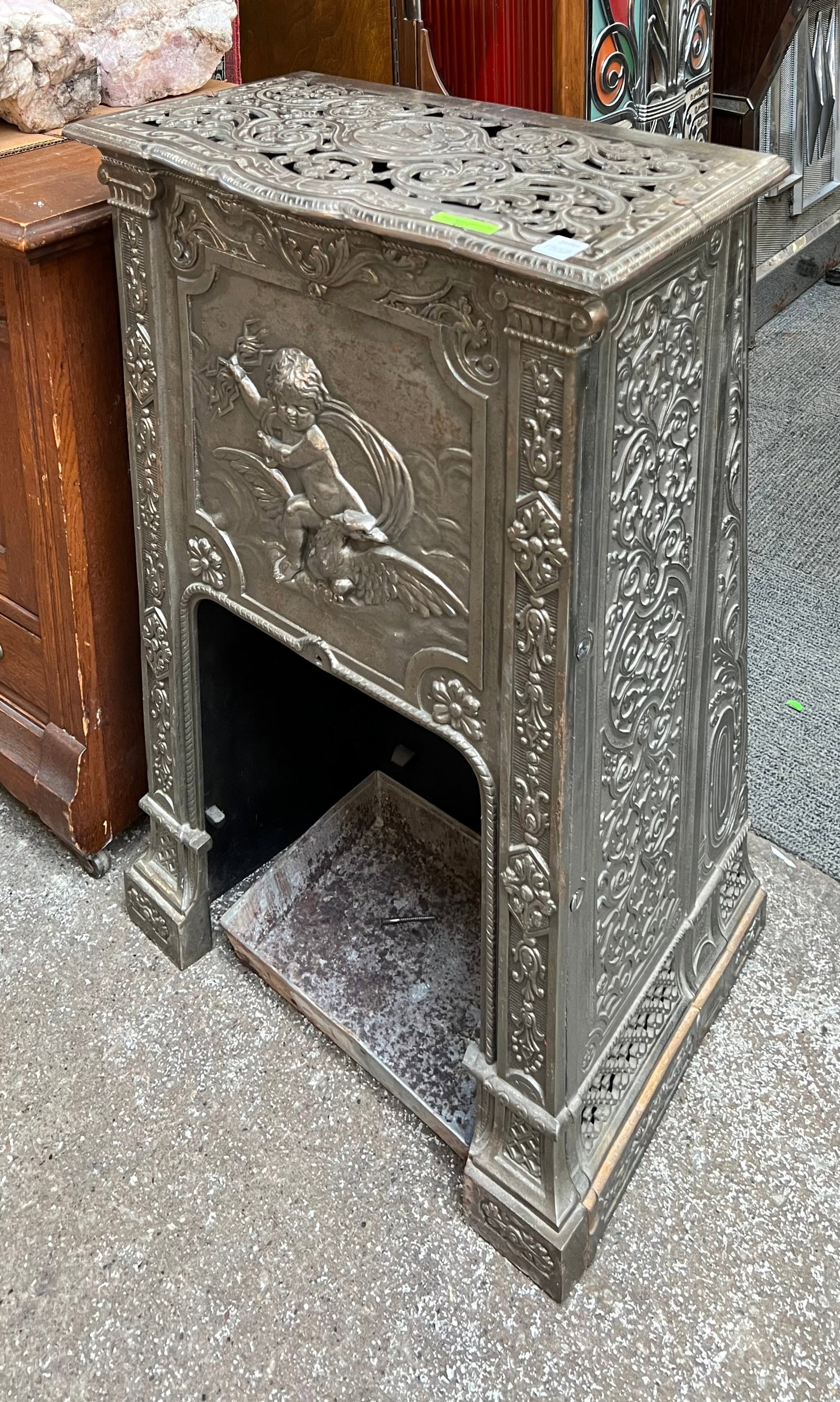 Nickel Plated Antique Stove or Fireplace.: This fine nickel plated stove or fireplace has a cherub and floral design. It is in good used condition, with some scratches. It measures 31 1/2" tall, 20" wide, and 11" deep. Third-party freight ship
