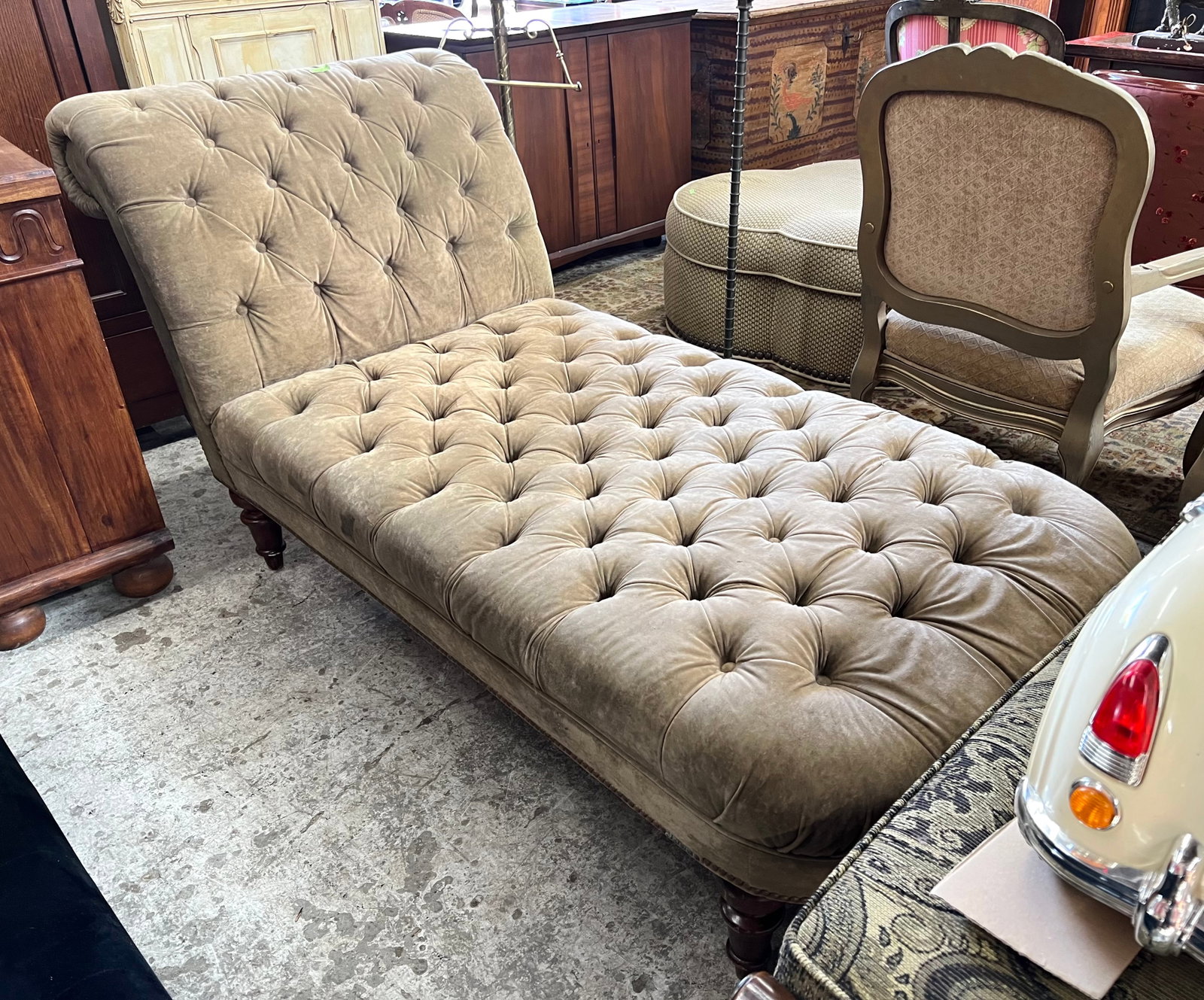 Contemporary Fainting Couch.: This is a comfortable light brown fainting couch, with button tufted details and a nailhead trim. It is in overall good condition, though there are a couple of stains on one side, as well as a tiny ho