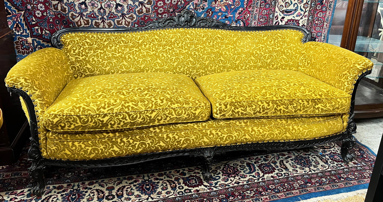 French Carved Sofa with Chenille Upholstery.: This is a carved two cushion sofa with yellow chenille upholstery. The carved crest on the back rest has a bruised top. The sofa is in overall good condition with some signs of wear. It measures 79" w