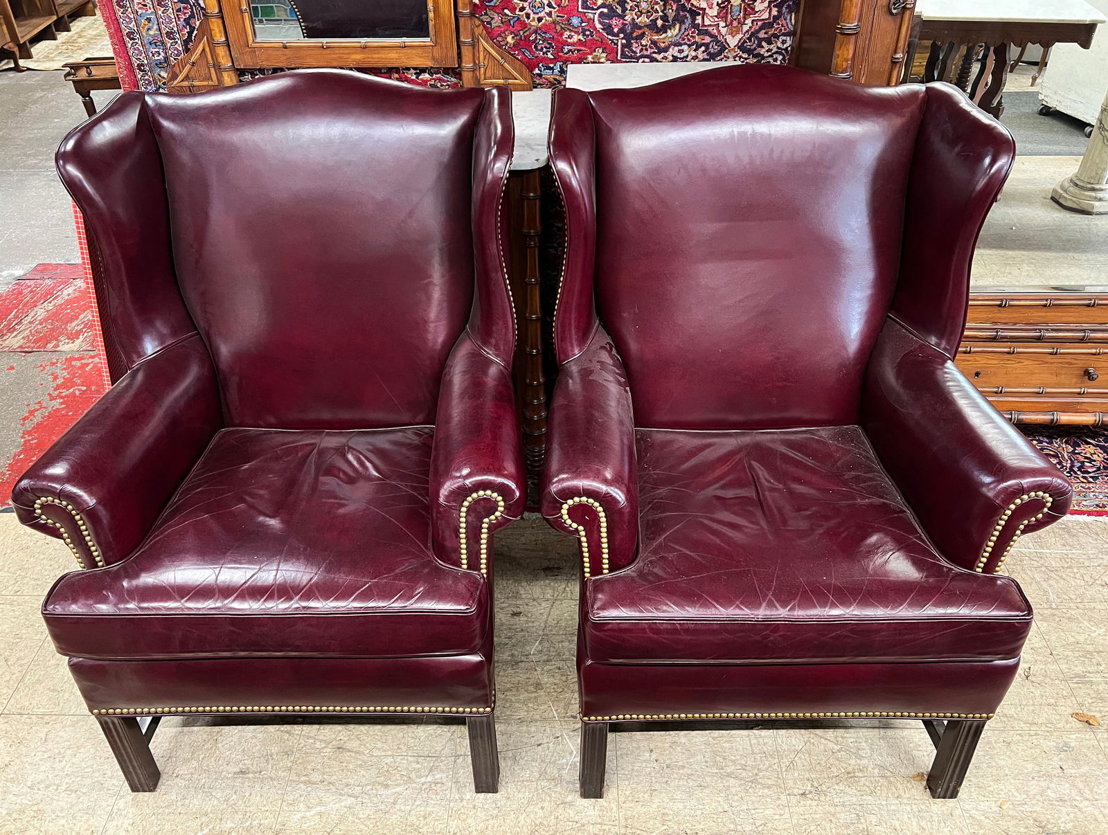 Pair of Hancock & Moore Leather Wingback Chairs.: This is a Fine Pair of Burgundy Leather Armchairs signed Hancock & Moore. They have nail head trim. They are in good condition, with no damage to the leather. They each measure 31" wide, 41 1/2" tall,