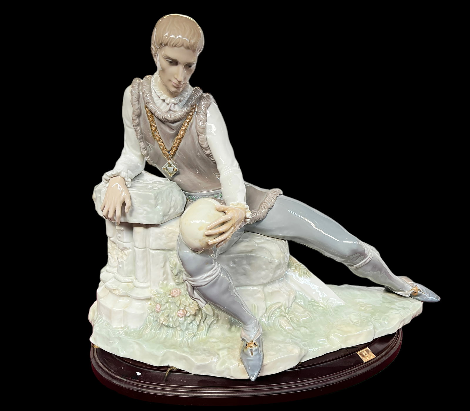 Lladro "Hamlet" Large Figure.: The Figure is of Hamlet is sitting outside, holding a skull. It looks as though his left hand has been Repaired; there is some glue residue and discoloration in that area. The figurine's measurements 