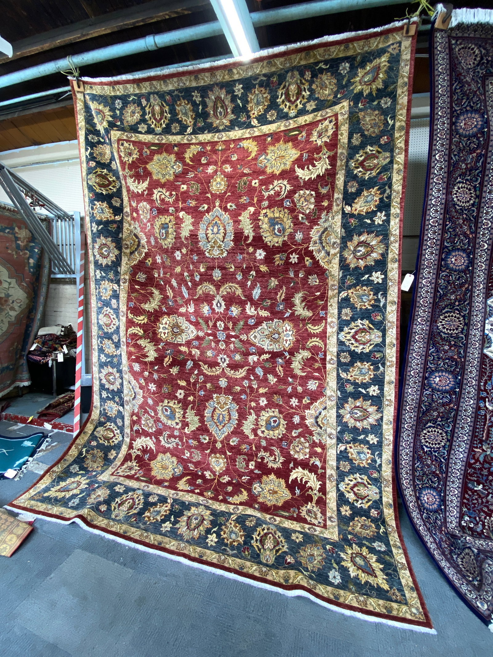 9' 10" x 14' 1" Green & Red Agra Rug.: The Rug looks to be in Good Overall Condition. In-House Packing and Shipping Services are Available for this Rug. Please see our Website regarding in-house Shipping Procedures.