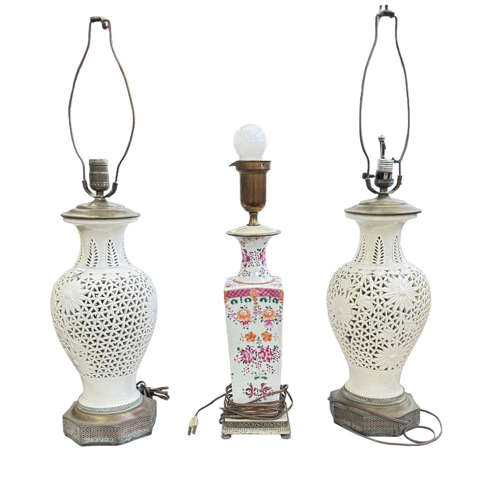 Lot of Three Chinese Porcelain Lamps.: This lot is comprised of a pair of Chinese reticulated white porcelain lamps, as well as a floral porcelain lamp. One of the white lamps has a large crack, and is missing a chunk of porcelain. All thr