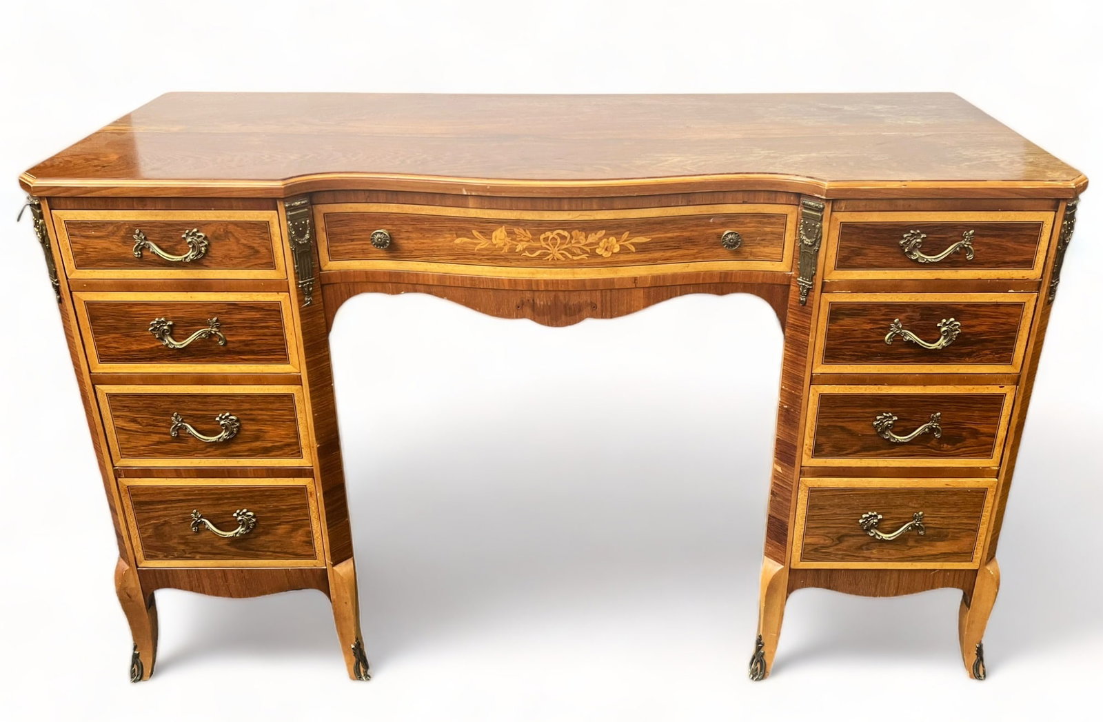 Inlaid French Style Desk with Bronze Mounts.: This French style desk has bronze or brass decorated mounts on the front and legs. The wood is possibly satinwood. The desk has nine drawers, each with its original hardware, as well as an inlaid flor