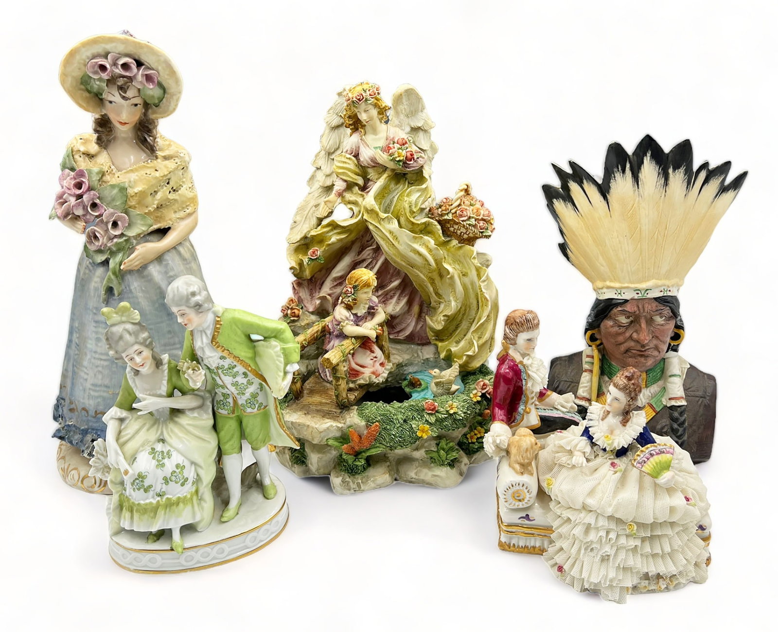 Lot of Mostly Porcelain Figures.: The figure with the Angle and Child is composition, and measures 11" tall. The tallest figure is a Cordey lady figurine, measuring 13" tall. There is an Irish Lace Figure of a Couple, a Germany Indian
