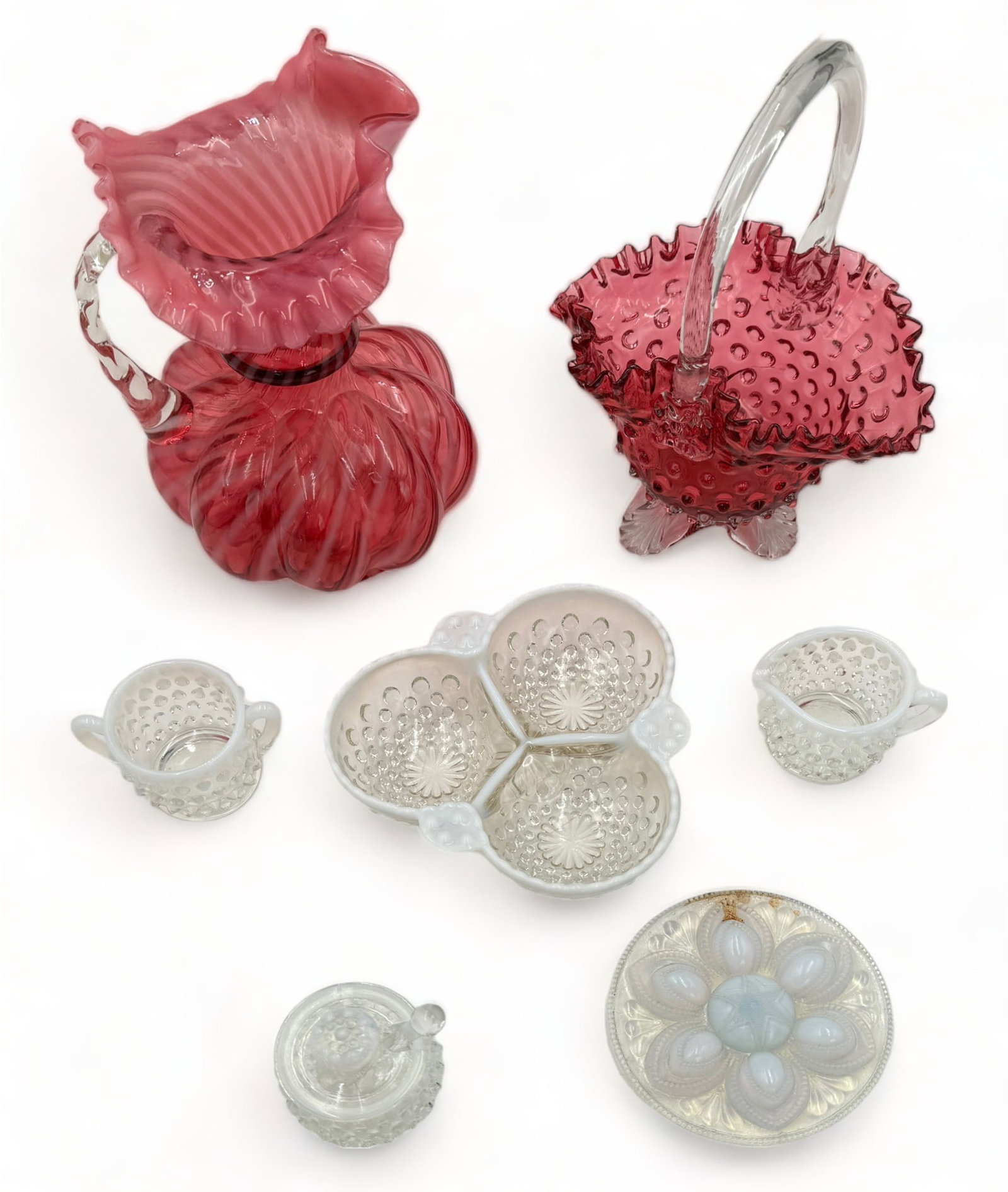 Lot of Vintage Glass - Fenton, etc.: Included are several hobnail glass pieces, likely Fenton Moonstone. Also included in the lot are a ruffled basket (very damaged - has a crack - see photo), and a cranberry glass pitcher. The opalescen
