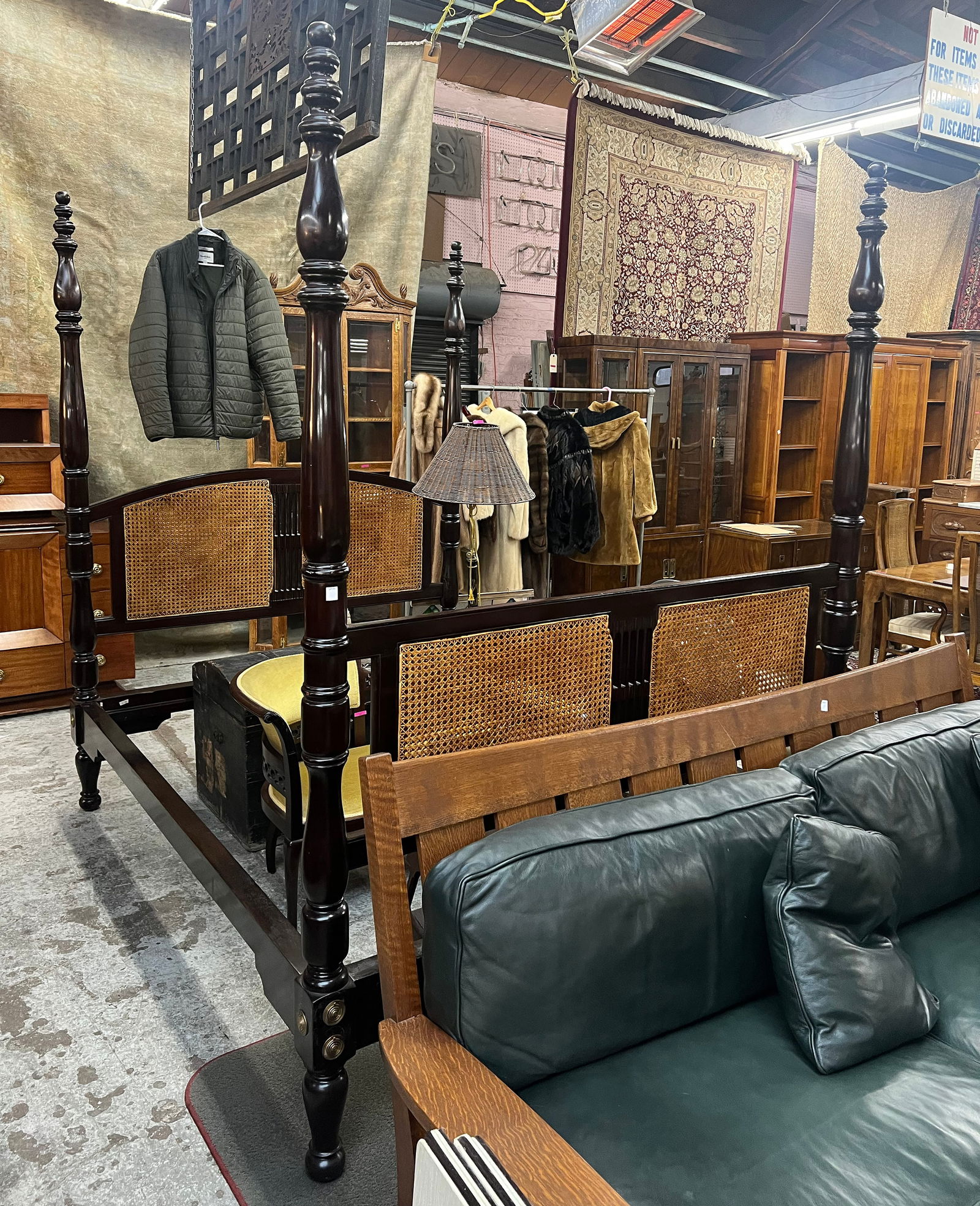 Dark Wood and Cane Four Poster Bed.: This dark brown four poster queen bed has a carved headboard and footboard. There are some scratches on the wood, but no visible damage to the cane. The headboard measures 66" wide and 88" tall. Third