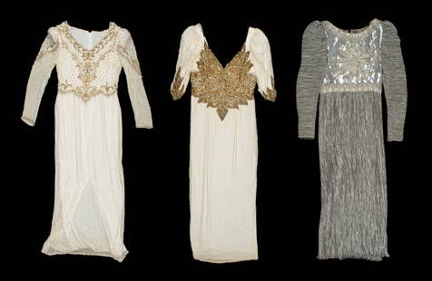 Lot of Three Vintage Beaded Evening Gowns.: This lot contains two white beaded and sequined dresses, as well as a gray Mary McFadden ? dress. The latter is unmarked. The white dress with a golden bodice is tagged as a size 12, with a 100% silk