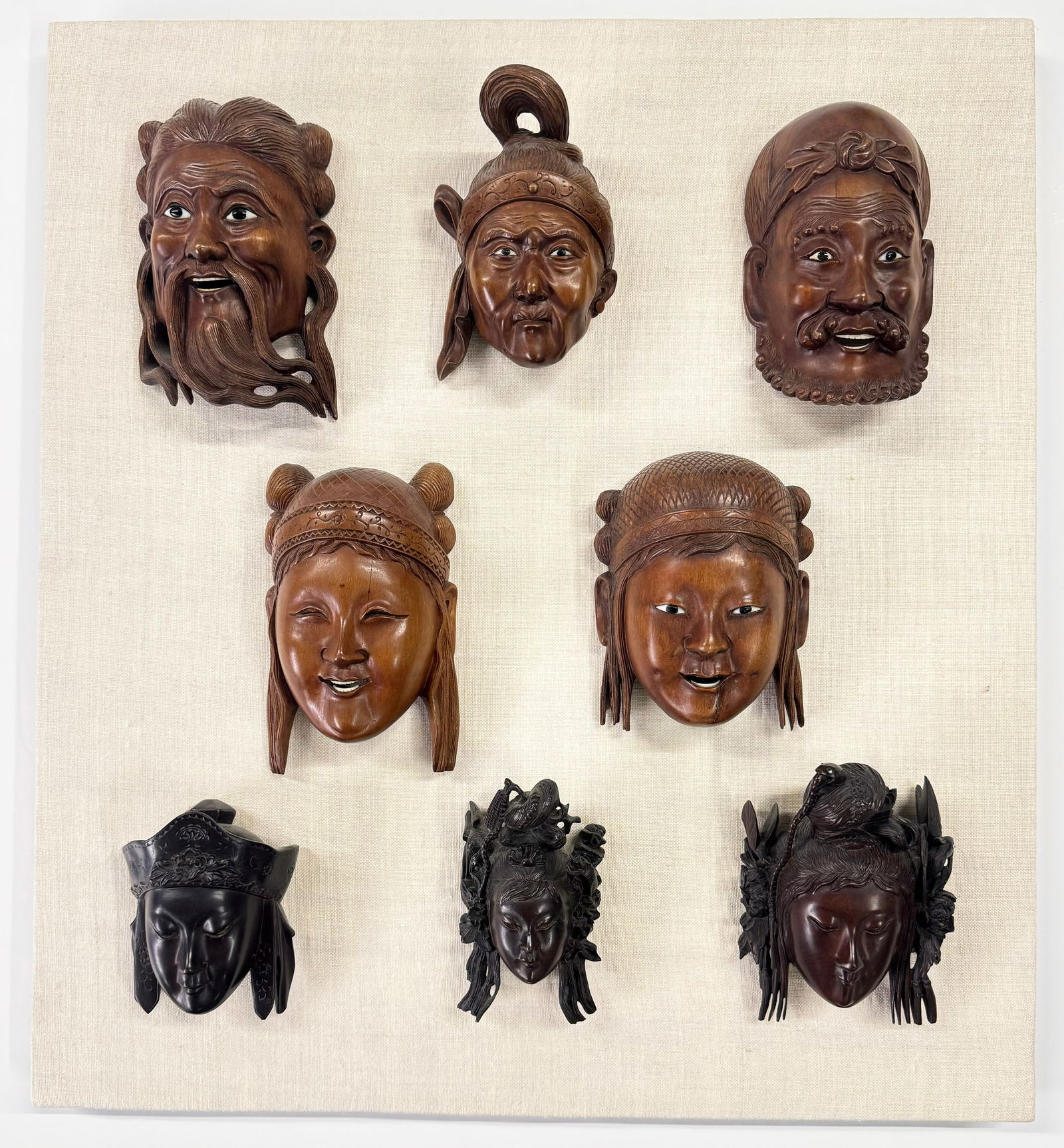 Display Board w/ 8 Fine Carved Asian Face Plaques.: They look to be in good condition, overall. Three of them have minor age cracks. The board measures 22" x 20". The faces range in size from 4 3/4" long to 6 1/4" long. In-House Shipping is Available.
