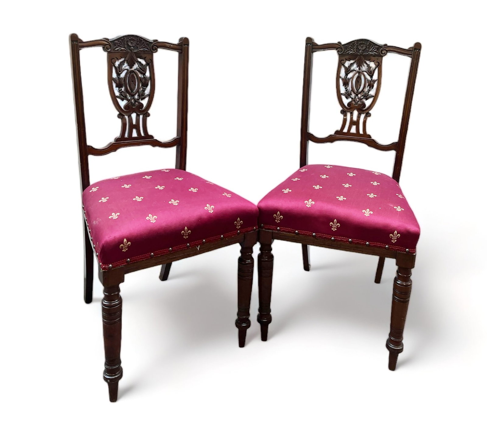 Pair of Carved Victorian Side Chairs.: These Victorian chairs have red and gold fleur de lis upholstery and nailhead trim. The fabric could use a cleaning. They each measure 17" wide, 16" deep, and 34" tall. Third-party freight shipping or