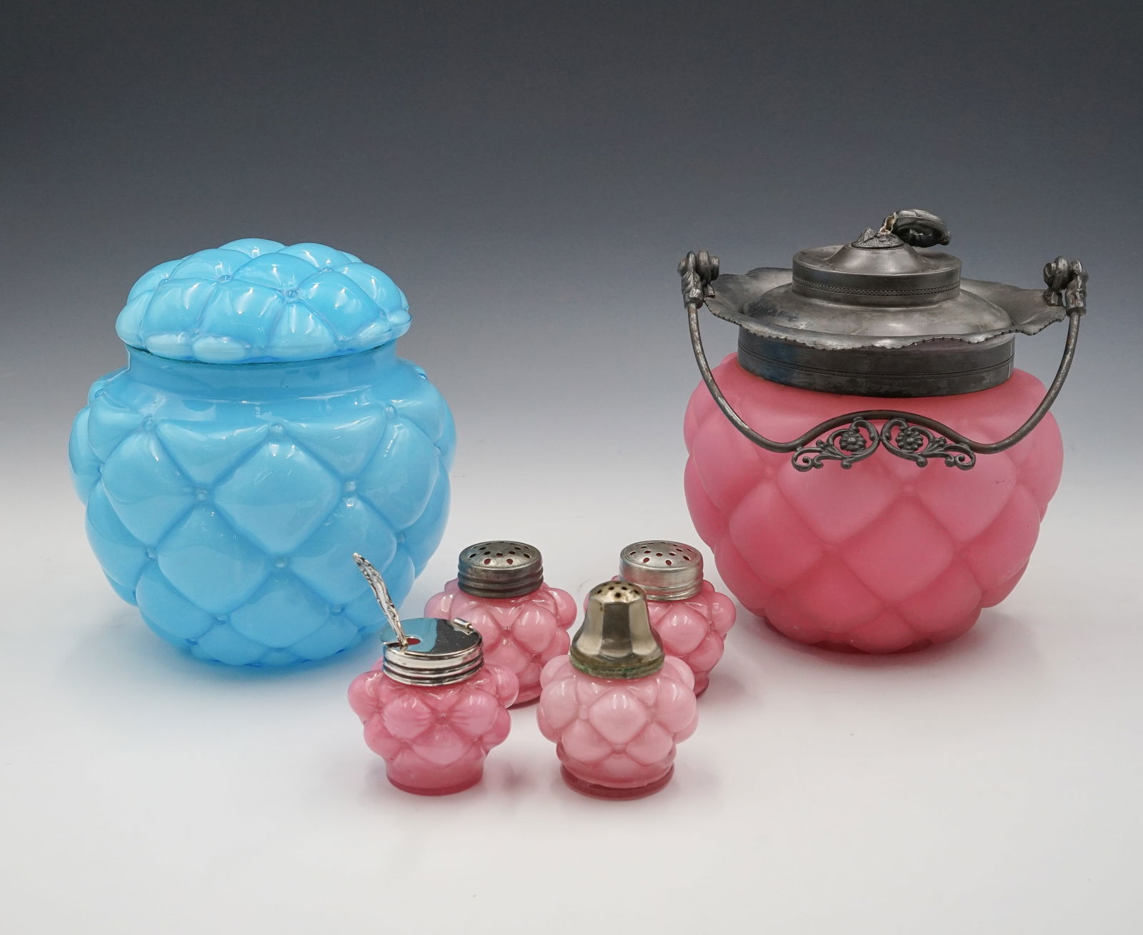 Lot: Consolidated Glass Biscuit Jars & Shakers.: Included are a sky blue glossy quilted jar with lid, a rose pink satin glass quilted jar with lid and handle, three small pink salt shakers, and a small pink condiment jar w/ Sterling spoon. The finia