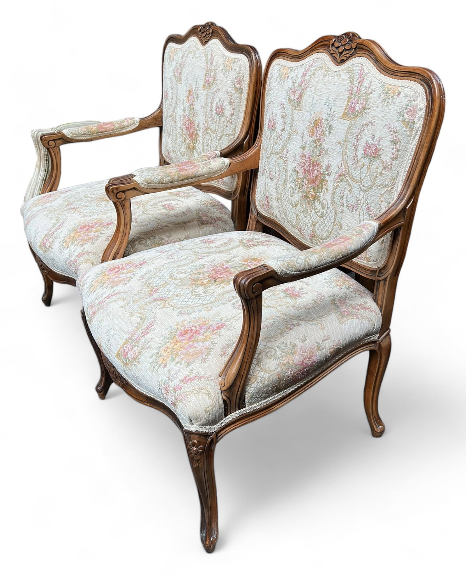 Pair of French Carved Armchairs.: This is a pair of French Louis XV style upholstered armchairs. The carved armchairs have a white, red, and yellow silk-type fabric, with floral decorations. Both chairs show signs of wear, especially 