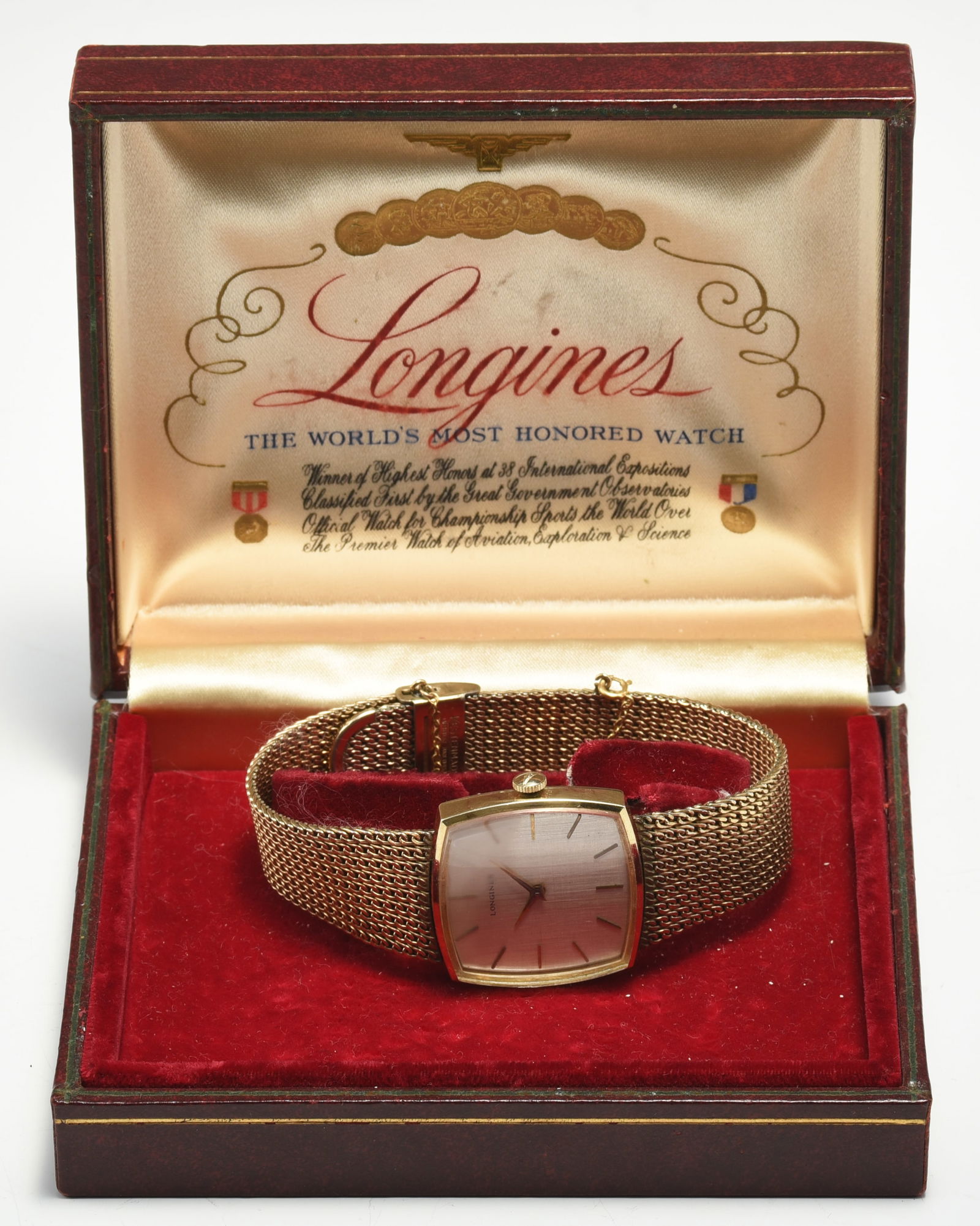Longines Gold Filled Men's Wristwatch.: This lot is a vintage Longines wristwatch with its original mesh band and box. The band and watch measures 9" in length and 5/8" wide. The curved square face measures 28mm x 30mm, and is 1/4" thick. T