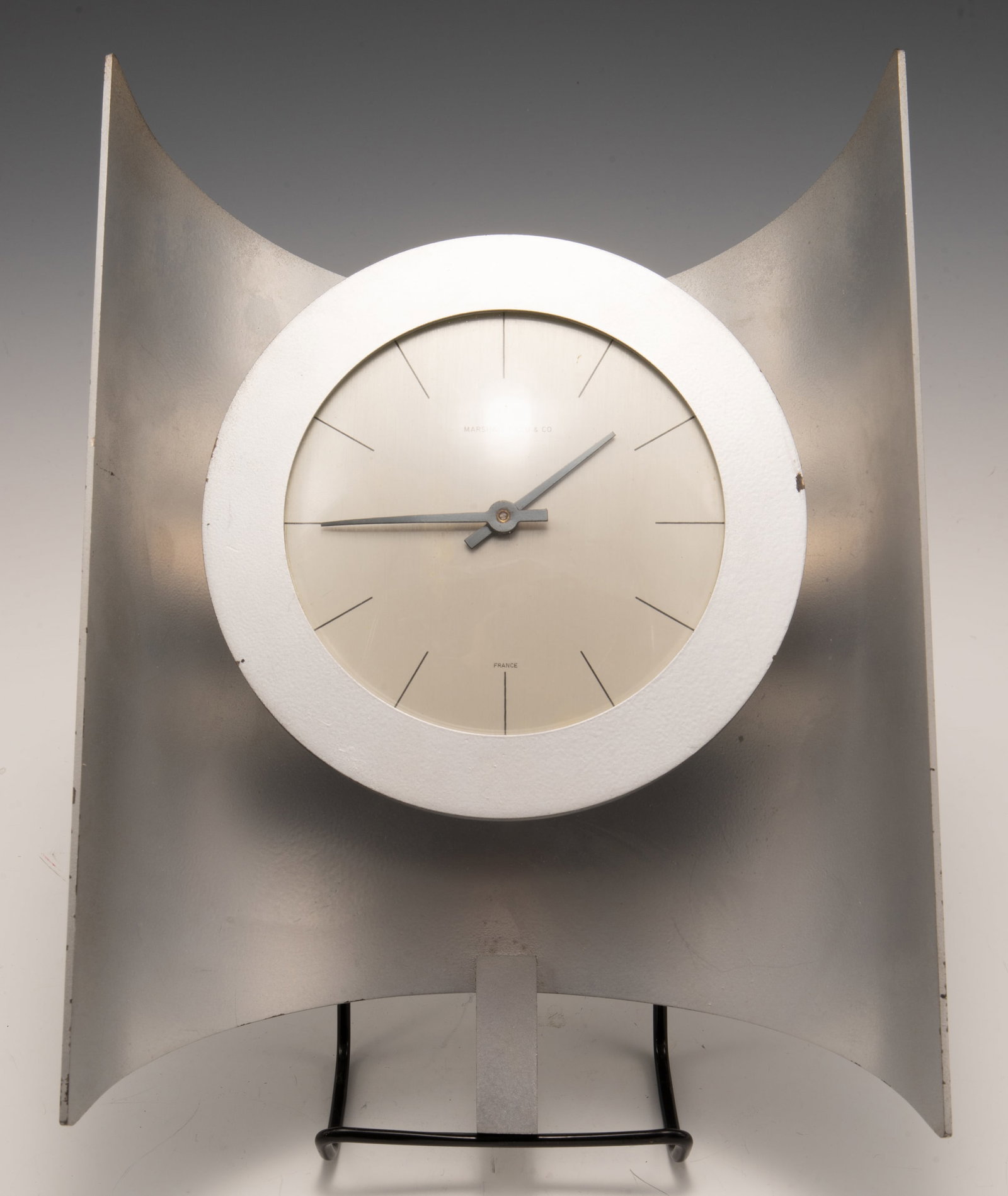 Modern Marshall Field & Co. Clock, Made in France.: The clock's Working condition is Unknown. It is a metal clock with a painted matte silver finish; there is some Paint Loss and minor surface wear present. The clock's Measurements are 7 1/2" x 3 1/2" 