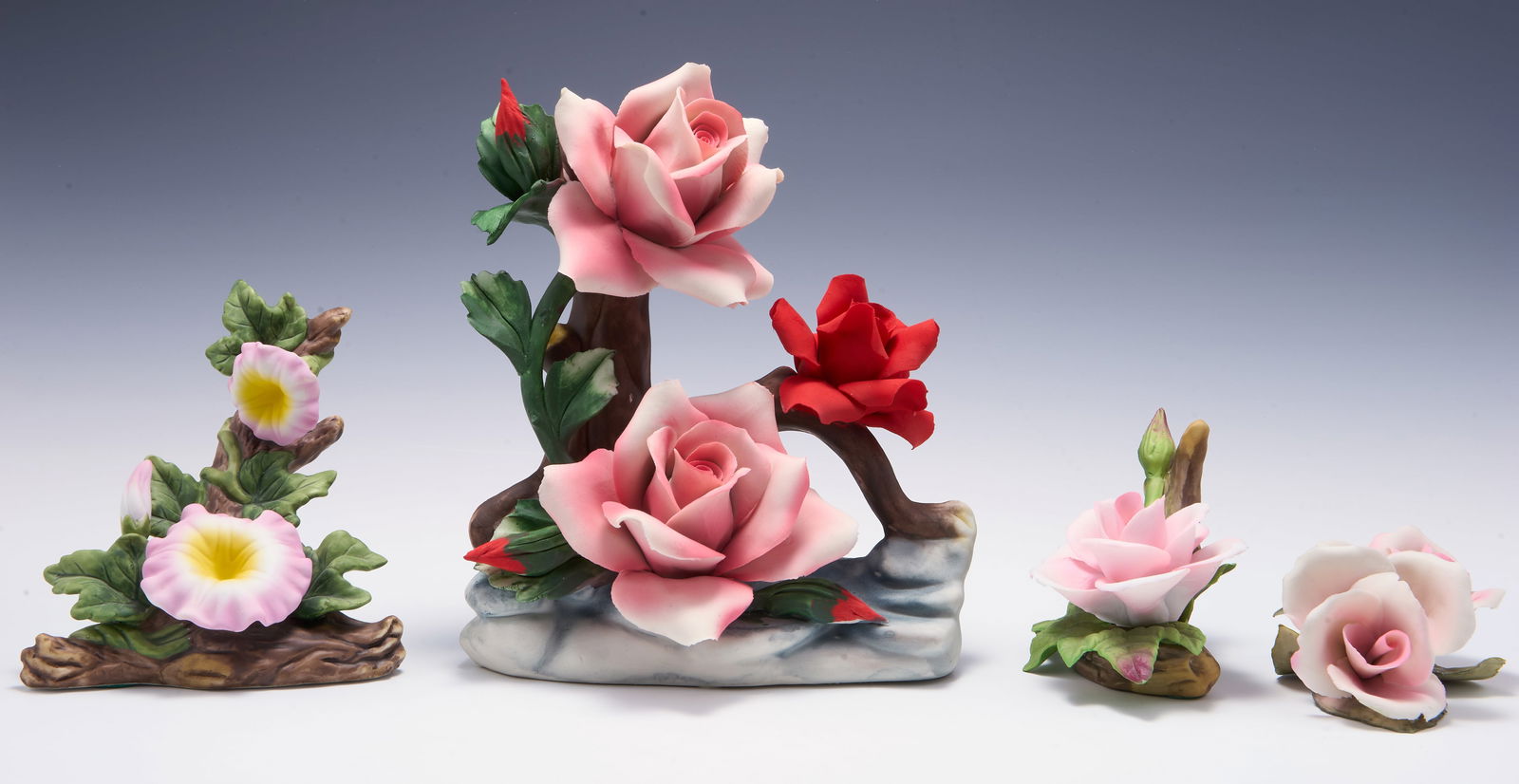 Lot of Capodimonte Porcelain Flower Figures.: This lot includes pink and red flowers- some small, some larger. They look to be in very nice condition. The largest figure measures 7" x 4 3/4" x 7 1/2". Third-party shipping or personal pickup is re