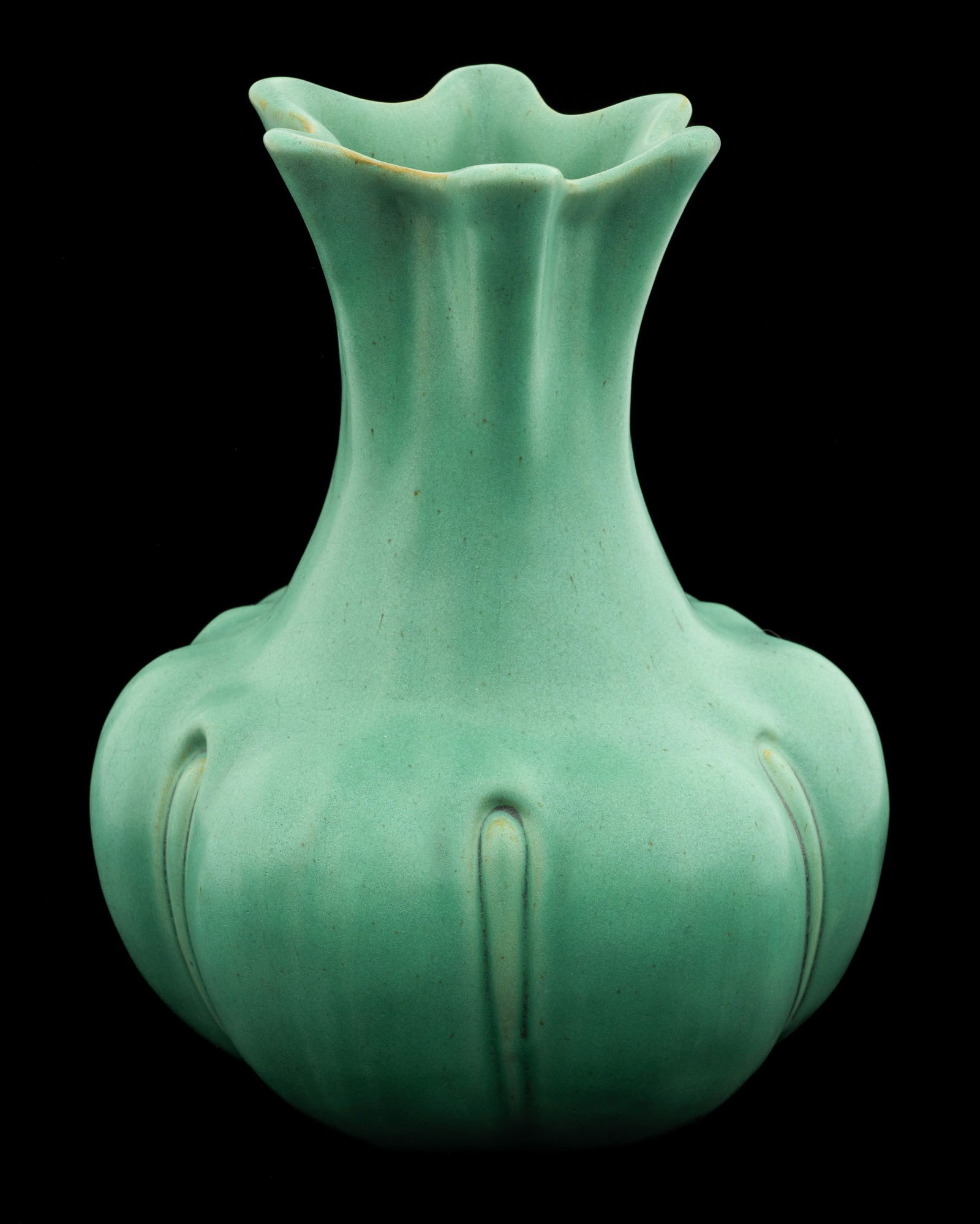 Teco Pottery Matte Green Squash Blossom Vase.: "Teco" is signed on the underside. The vase has a bulbous bottom with six partitioned sections. It has a six-pointed flared rim. Overall, the vase looks to be in very nice condition. Its measurements