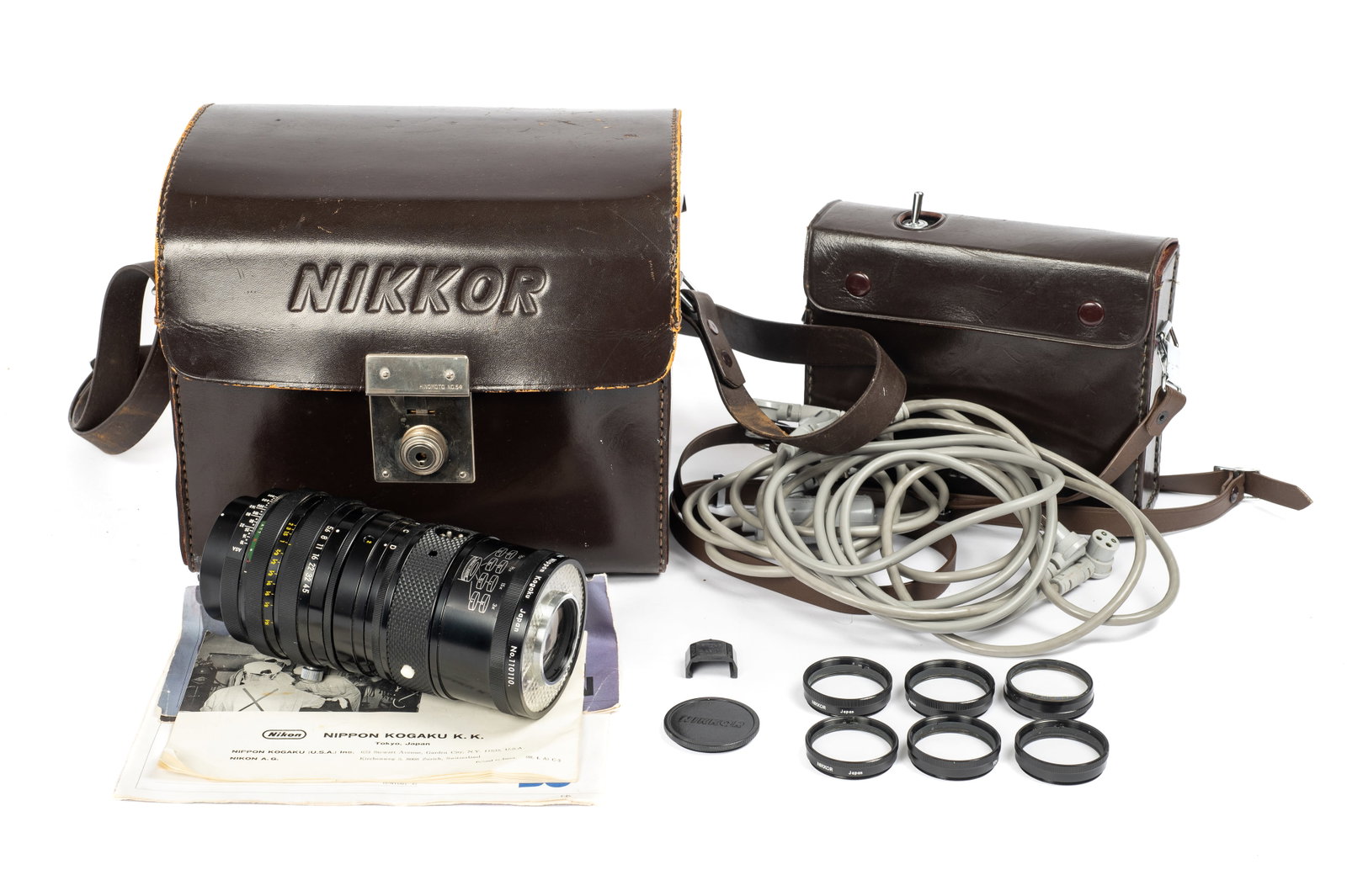 Medical-Nikkor Auto 200mm f/5.6 Lens & Accessories: The lens comes with its original leather case, AC adapter (with leather case & cord), six auxiliary lenses, multiple power source cords, safety cap, lens cap, instructions, and advertising literature.