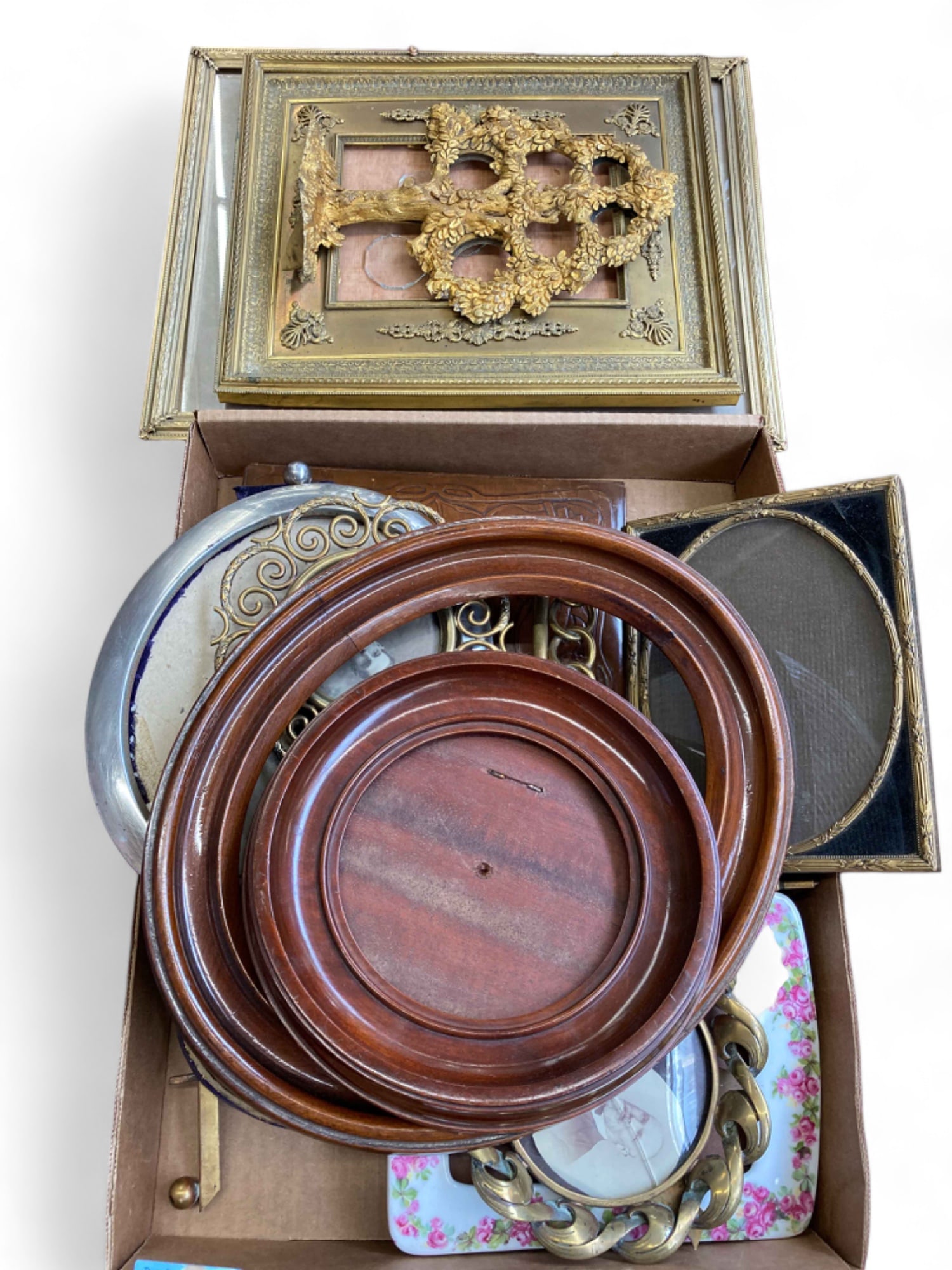 Lot of Antique Picture Frames - Brass, Wood, etc.: The lot includes 14 picture frames. Most of them are brass, but some are wood or aluminum. There is also a ceramic one, and a leather one. The smallest piece measures 5 3/4" in diameter. The largest i
