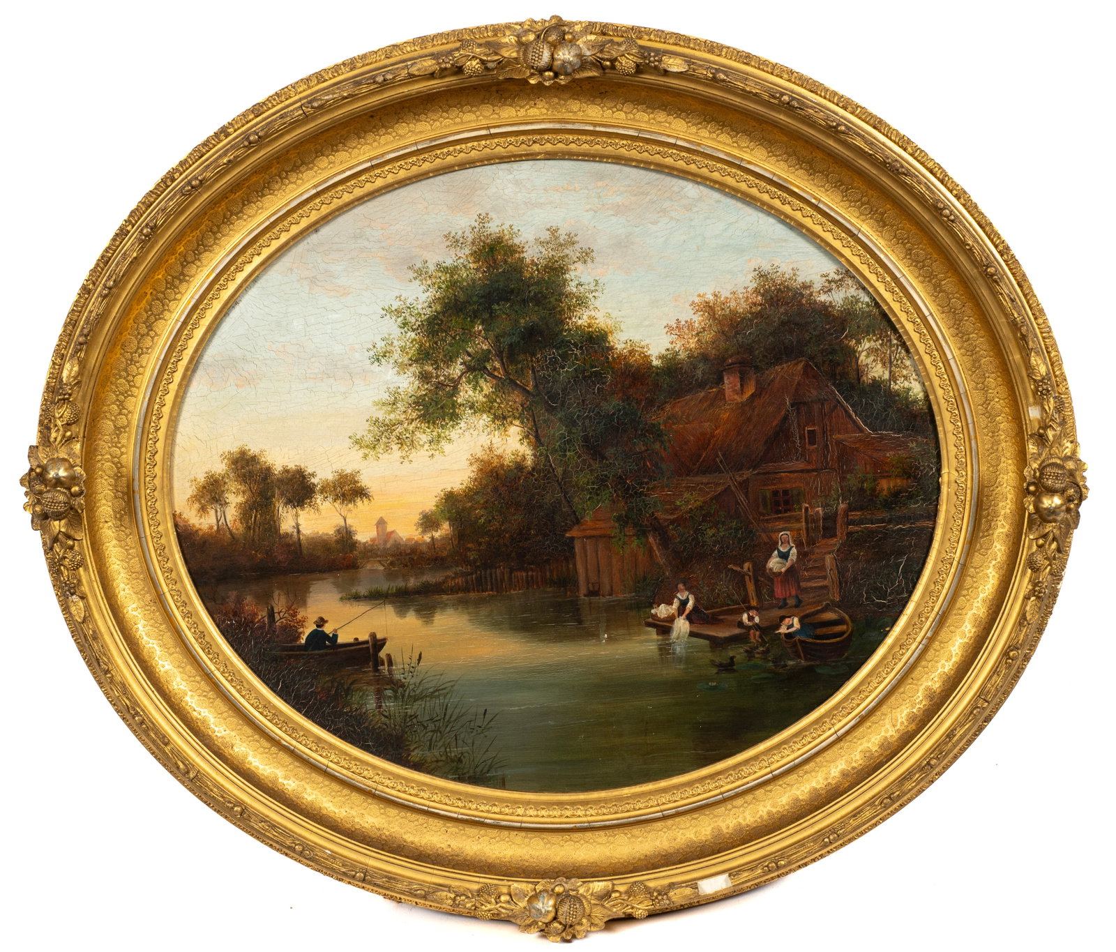 Unsigned Oval Painting of a River Scene.: This oil painting on canvas depicts a wood cabin on the river, with a family fishing and doing laundry nearby. The work is housed in an oval gilt frame. The painting has craquelure and flaking paint l