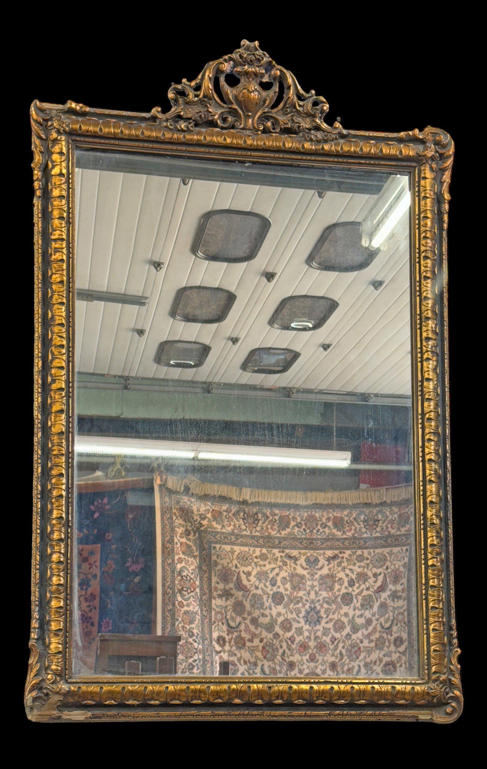 Gilt Wood Wall Mirror.: The mirror is decorated with an urn and flower motif. It has damage in the lower left corner, and very minor desilvering. It measures 32" tall and 22" wide. Third-party shipping or personal pickup is 