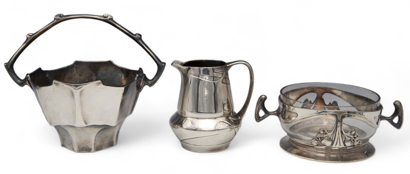 3 Urania Art Nouveau Silverplate Pcs - Adler ?: All are marked, "Urania", and may be by Friedrich Adler. The lot includes a creamer, a basket-shaped bowl, and a sugar bowl with handles. This last piece has some small chips on the glass insert. Over