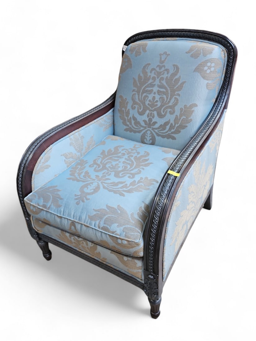 Art Deco Style Upholstered Armchair.: The chair features leaf carvings on the legs, and blue damask upholstery on the back and sides of the piece, in addition to the cushion and backrest. The chair is in good condition, with minimal wear.