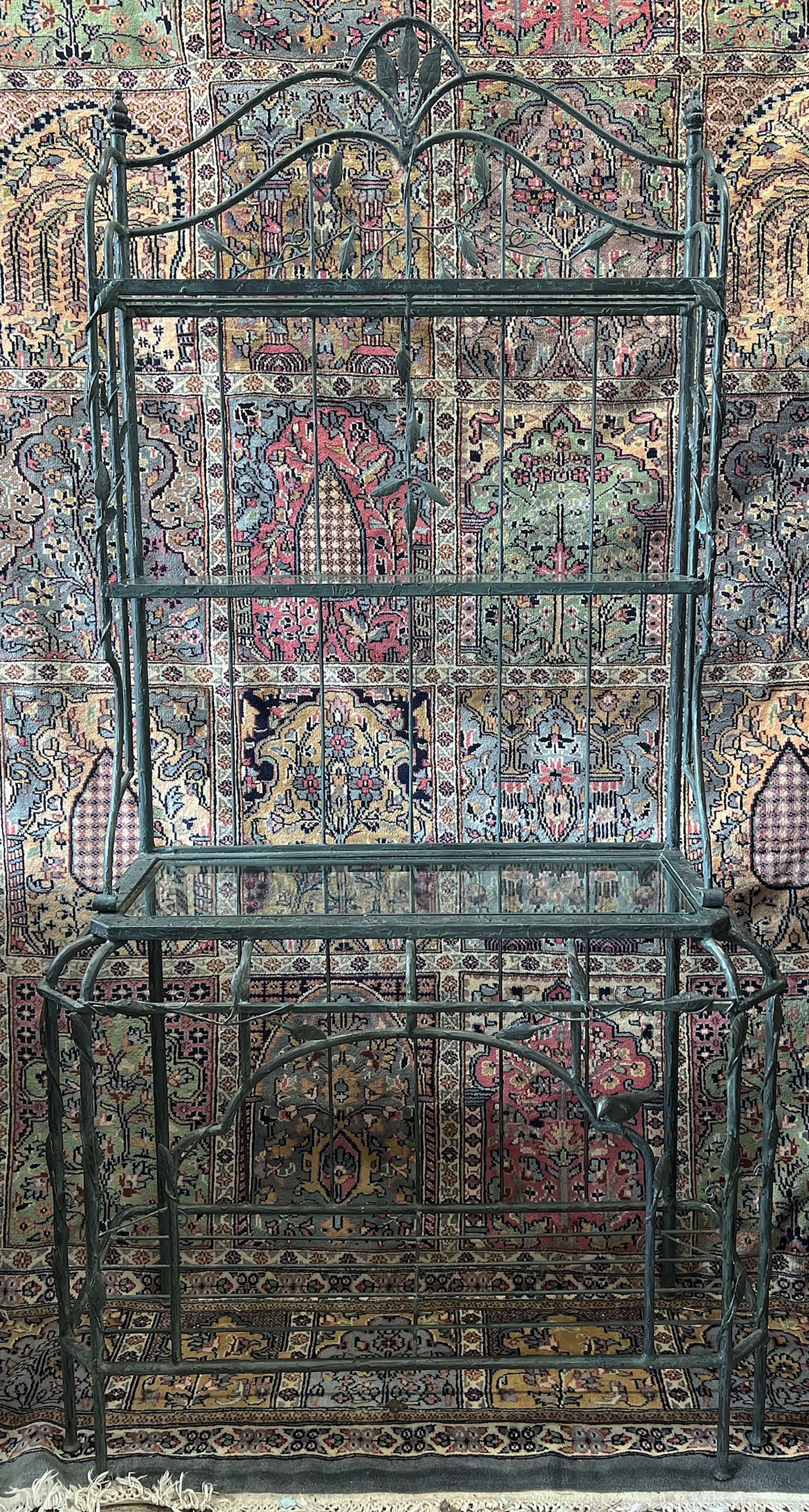 Metal Baking Rack with Leaf and Bird Motif.: The rack sports three upper glass shelves and one lower metal shelf. The entire shelf is decorated with twisting branches and leaves, with a bird on the front. It is in good condition, though one of t