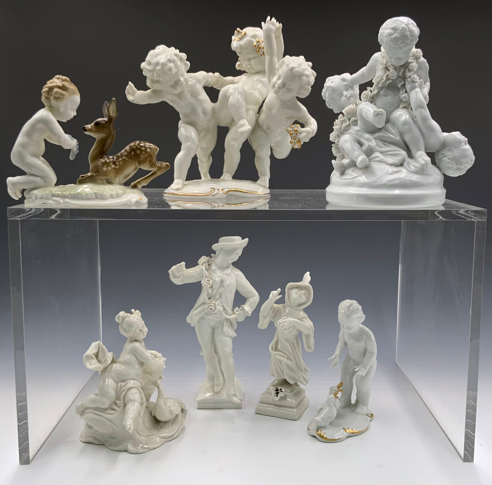 Lot of 7 German White Porcelain Figurines.: This lot contains porcelain figurines largely depicting cherubic children at play. The child with ducks is marked "Gerold Porzellan - Bavaria". The child kneeling with a deer is marked "LHS Hutschenre