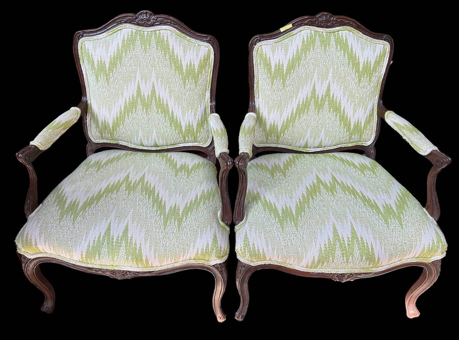 Pair of Louis XV Style Armchairs.: These chairs have light wood frames, carved floral details, and flame style upholstery. They are manufactured by the Schoonbeck Company (the label is on the underside). There are a few scratches, but 