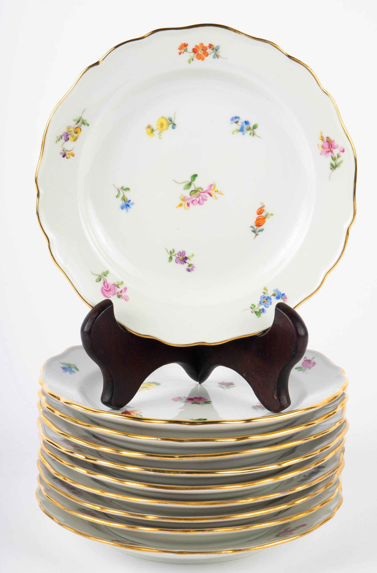 Lot of 10 Meissen Porcelain Floral & Gilt Plates.: The lot consists of ten hand painted 7" plates. Each plate features varied scattered flowers and gilded wavy edges. Each plate is marked and numbered on the underside. The plates may have some speckle