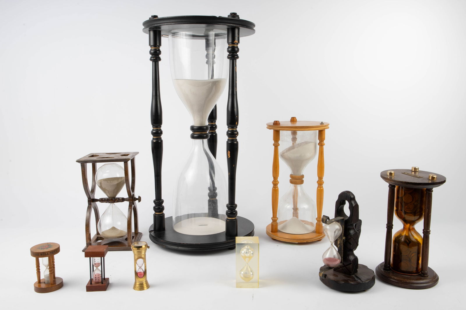 9 Antique / Vintage Hourglasses - Spain, Italy.: The lot includes 9 hourglasses. Most of them are made of wood, one is encased in acrylic, and one is brass with Buler date clock. One of them has a sticker that reads 'Made in Italy', and another 'Mad