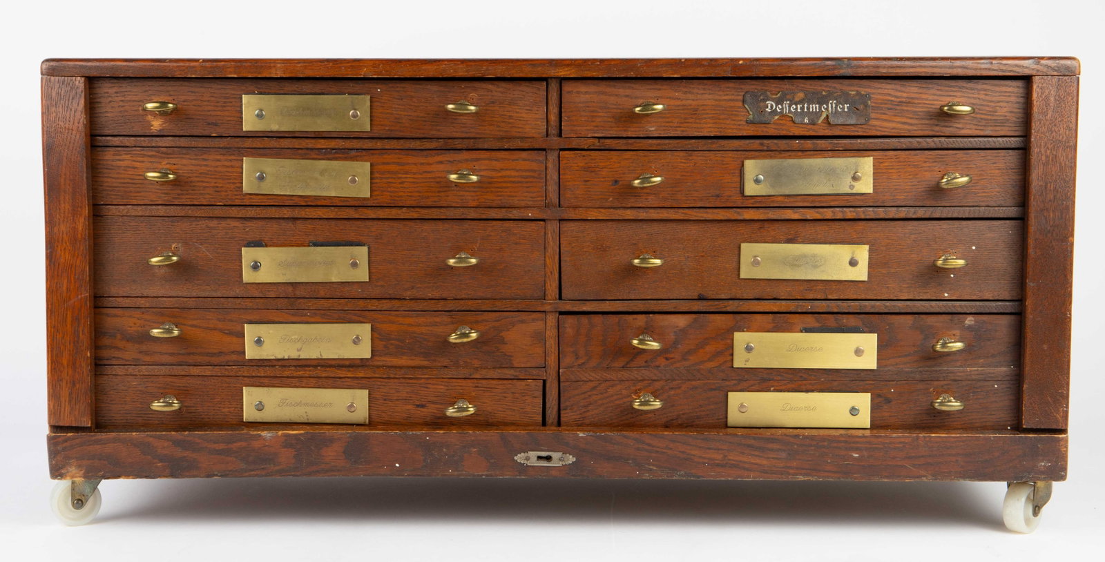 9-Drawer German Wood Flatware Cabinet.: The drawers are labelled in German with engraved nameplates. There are several scratches and other signs of wear, but the cabinet is still functional. Its dimensions are 32 1/4" x 15 1/4" x 12 1/2". T