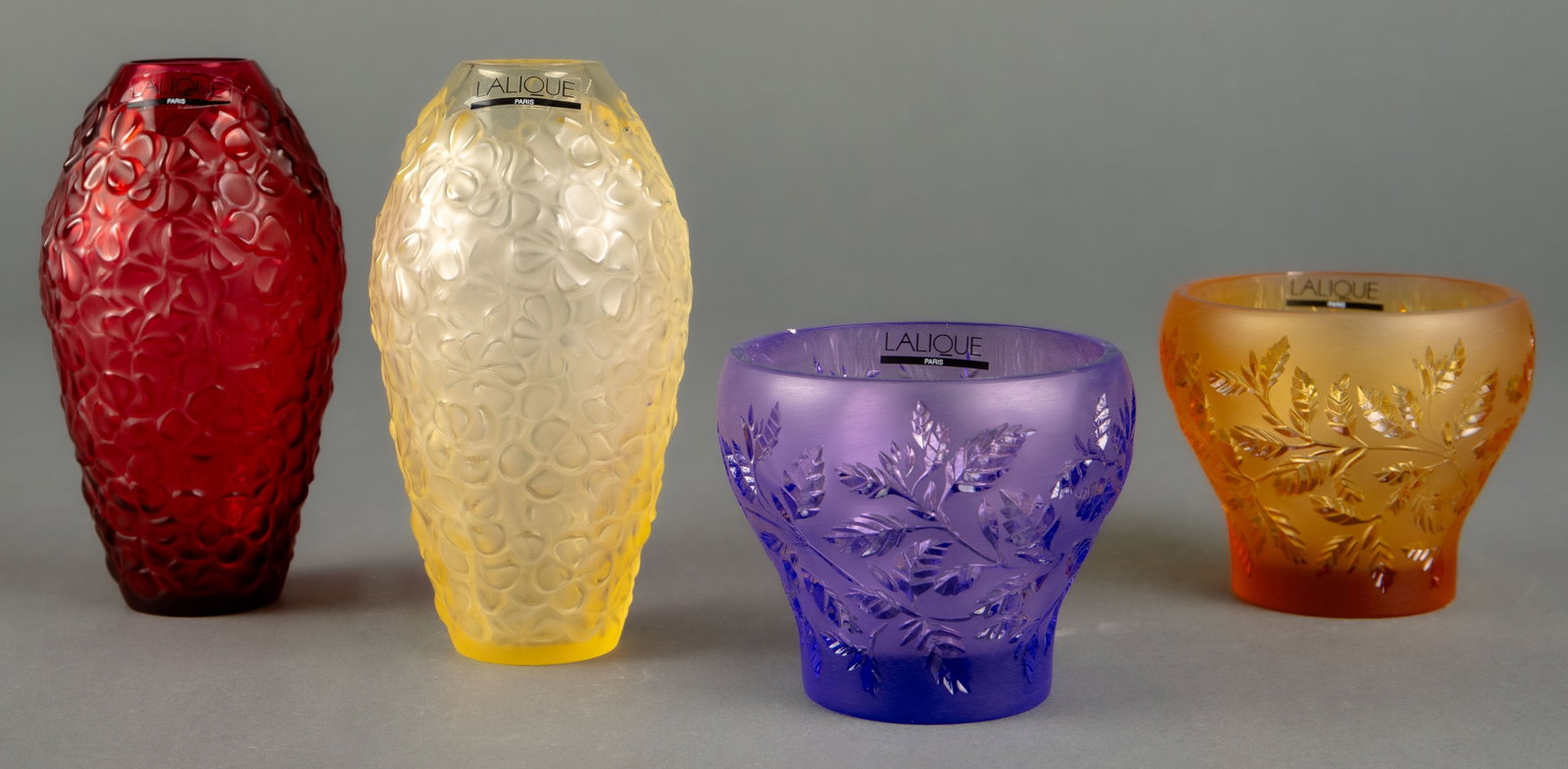 Lalique Multicolored Violeta Vases & Votives.: The lot includes 4 pieces by Lalique Paris. Every piece is hand signed on the underside. First, there are 2 "Violeta" vases - one in yellow, and one in red. They measure 5 3/8" tall and 3" in diameter