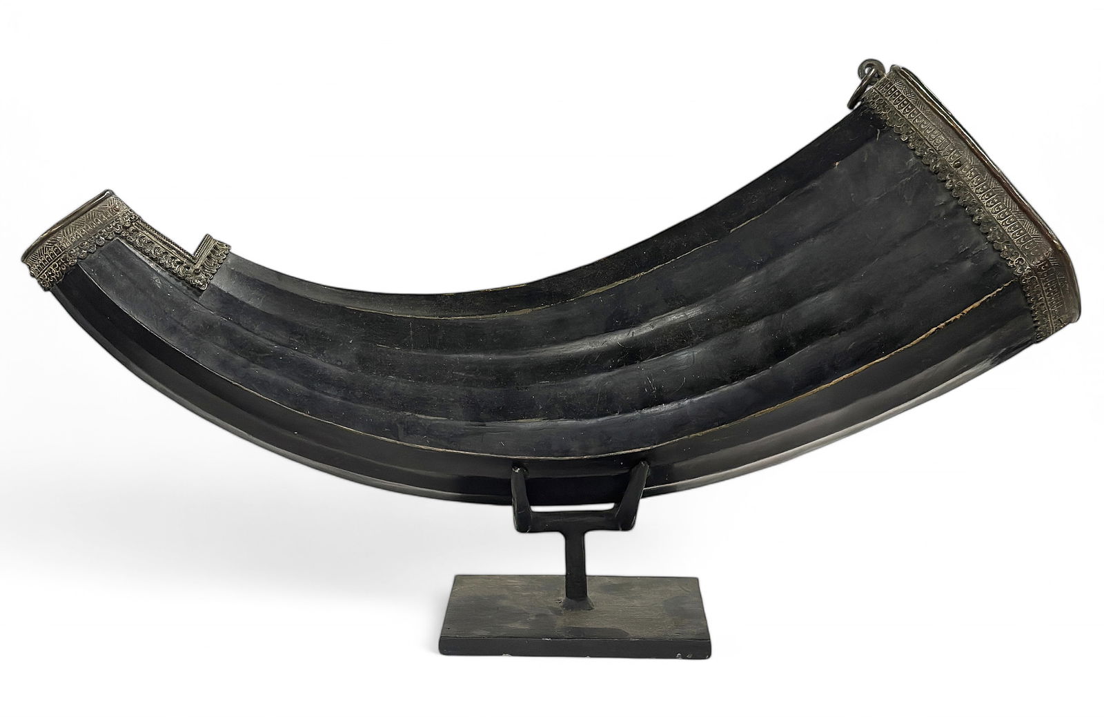 Large 19th Century Tibetan Drinking Horn / Flask.: The horn appears to be an ox horn or yak horn, with copper mounts. The piece has some wear to use. It measures 23" long. It comes with a metal and wood presentation stand. In-house shipping is availab
