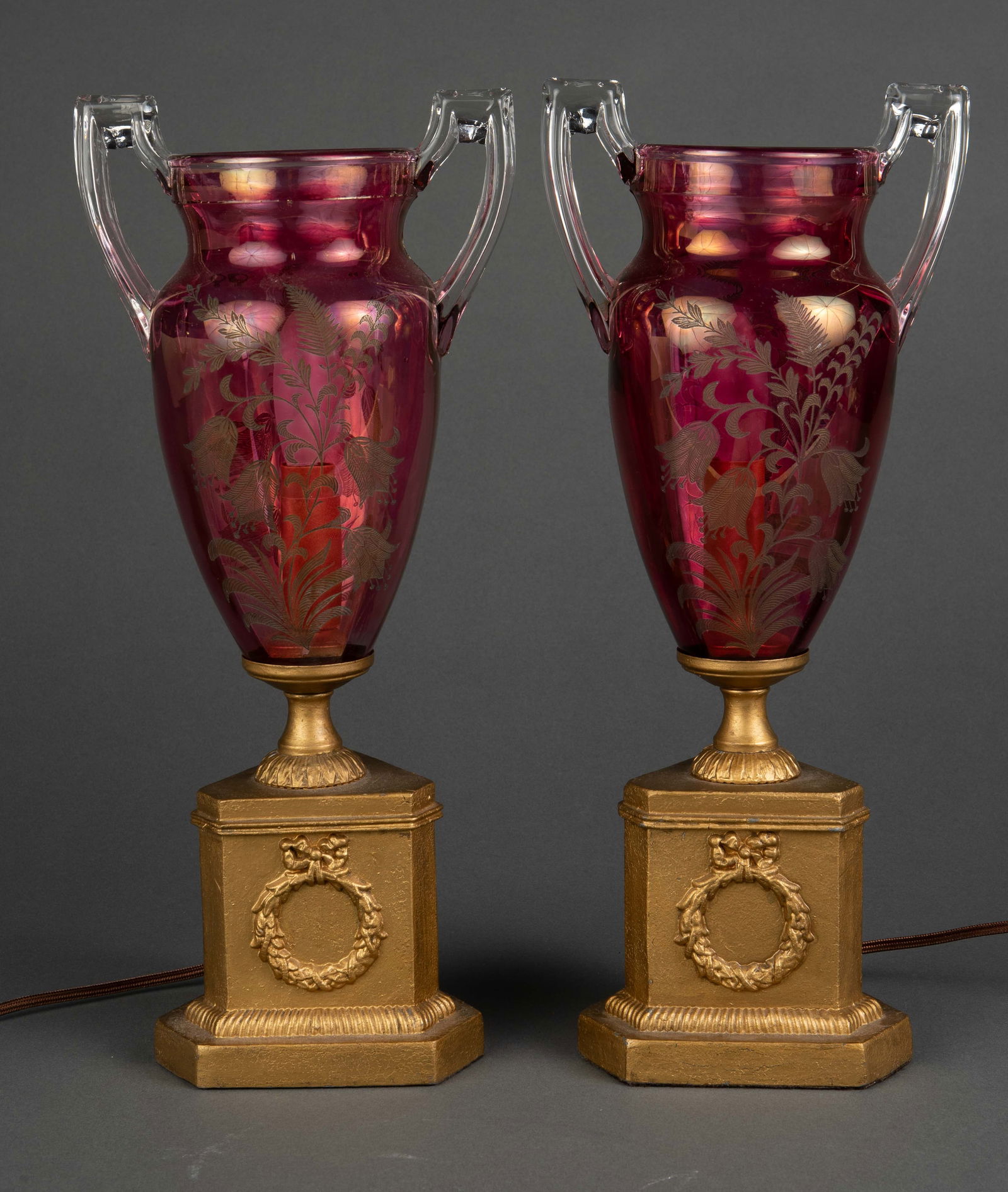 Pair of Victorian Style Pink Glass Lamps.: This pair of electrified lamps feature colored glass vase shades. This coloration is apparent by some scratches on the inside of the vase that reveal clear glass. The lamps measure 14 3/4" tall, 6 1/2