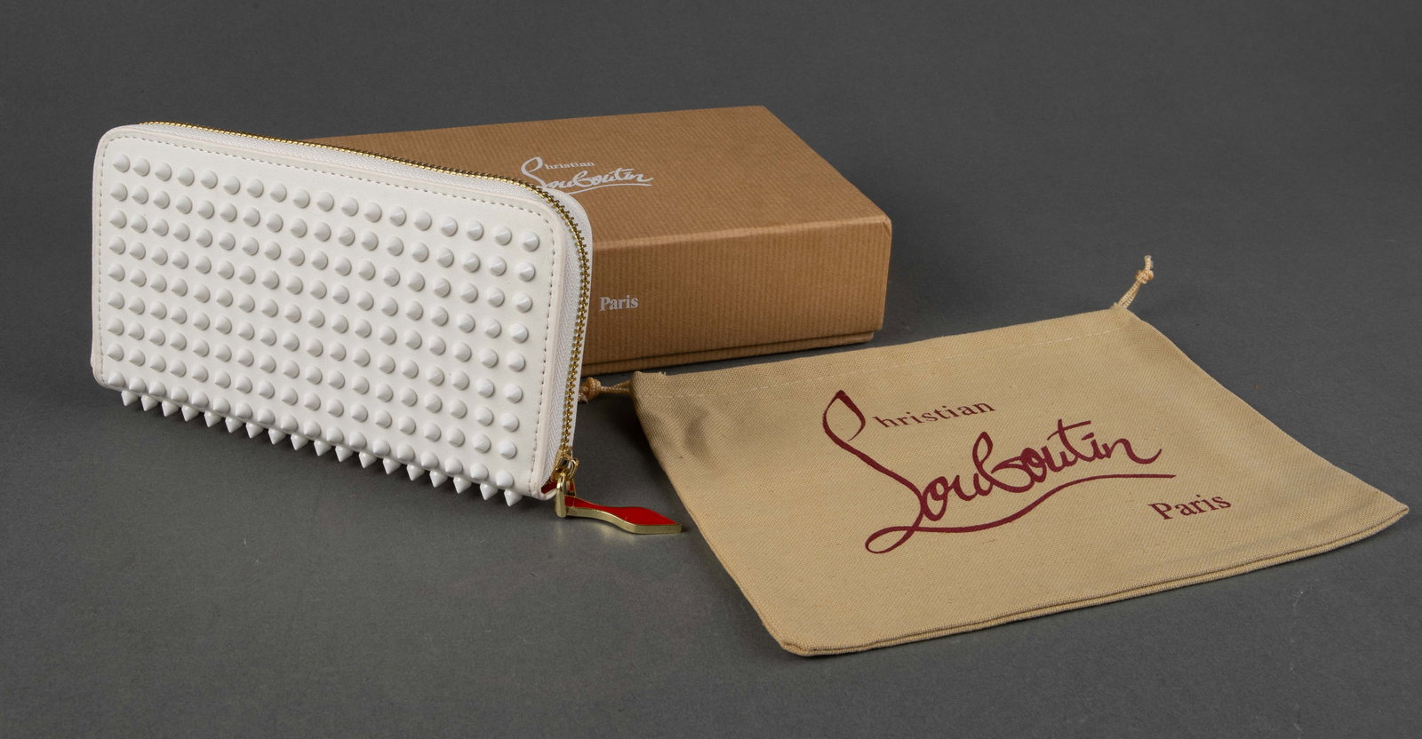 Louboutin White Panettone Spike Stud Wallet.: This leather wallet comes with its original box and dust bag. It measures 4 3/4" x 8" x 1 1/2". The interior is lined in red. The red heal keychain has a white 1/4" scratch. The item may have some min